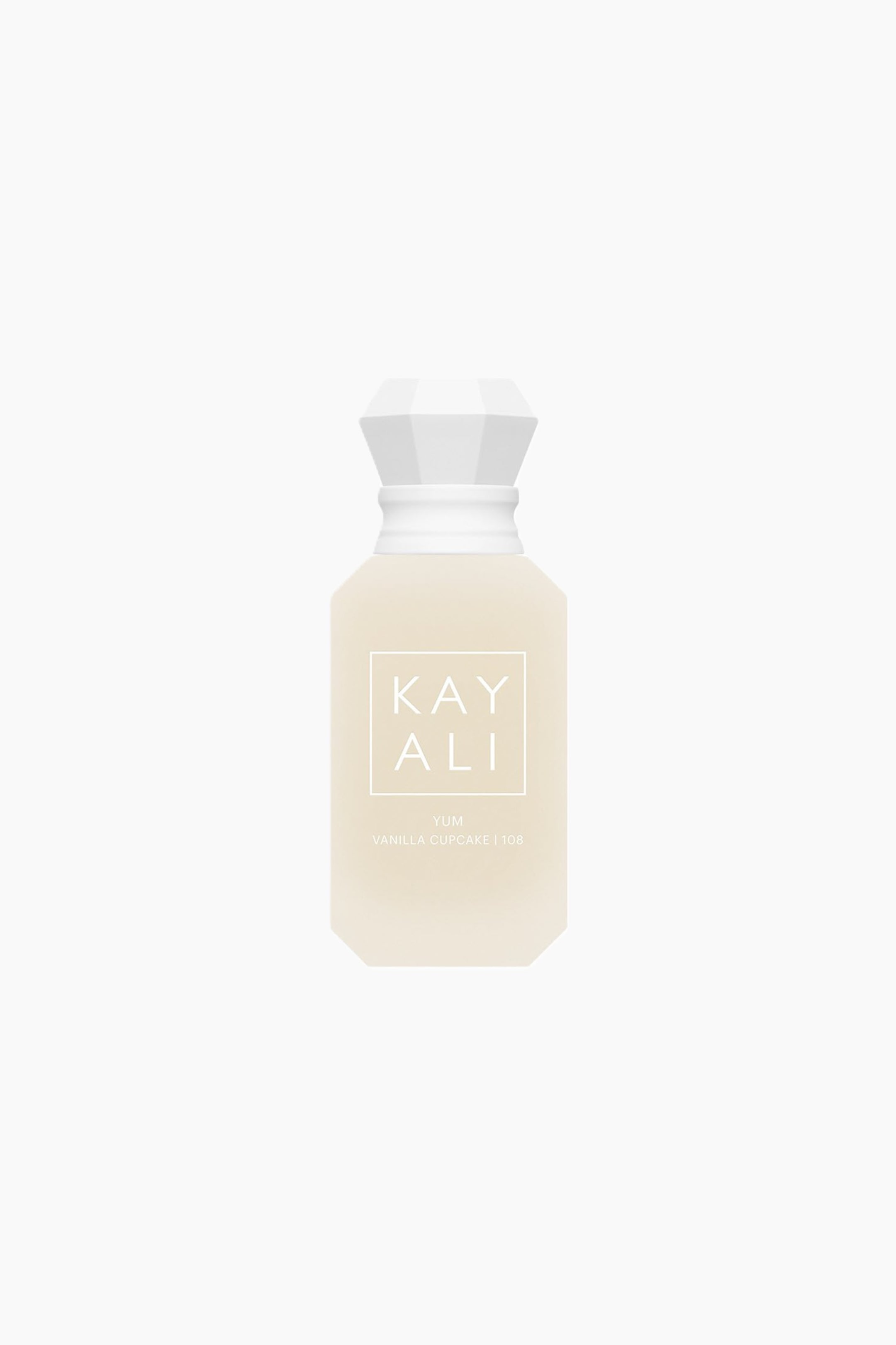 Näytä suurempi kuva: Edestä kuvattu näkymä Kayali Yum Vanilla Cupcake | 108 Eau de Parfum -pullosta, jossa on huurrettu, vaalean kermanvärinen kahdeksankulmainen lasipullo ja sen päällä valkoinen, jalokivimäisesti fasetoitu korkki. Pullon etupuolella näkyy brändin nimi ”KAYALI” valkoisen neliökehikon sisällä, ja sen alla on valkoisella painettuna ”YUM VANILLA CUPCAKE | 108”.
