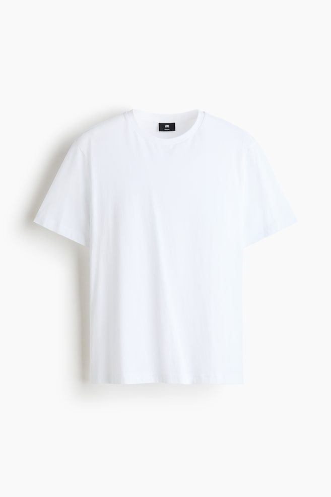 Een effen wit T-shirt is van voren afgebeeld, met een klassieke ronde hals, korte mouwen en een rechte zoom. - 1