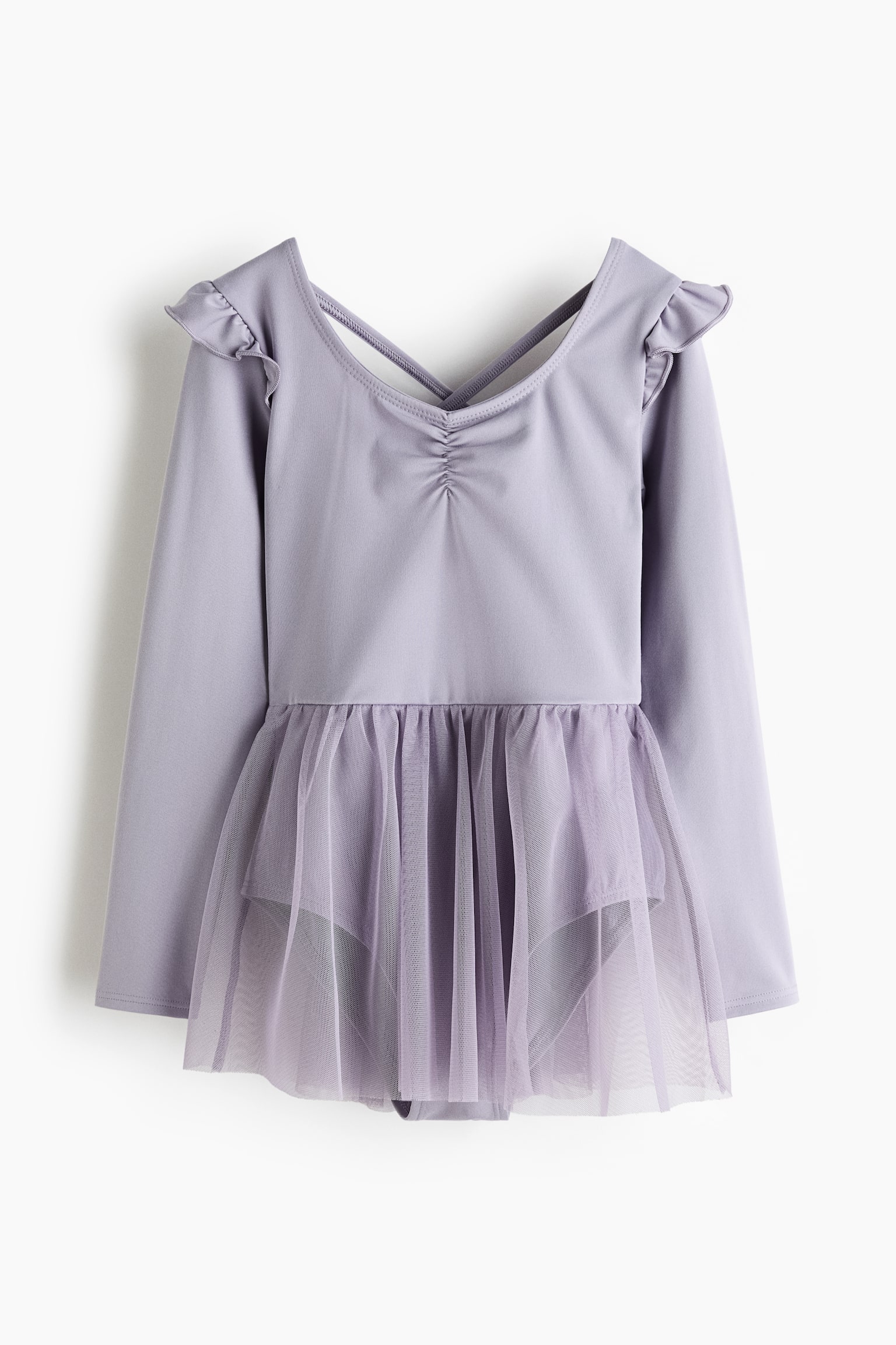 A lilac long-sleeve leotard is featuring ruffled shoulders and an attached sheer mesh skirt, gathered at the waist. The leotard is displaying a V-neck back with crisscross straps and central ruching. - 1