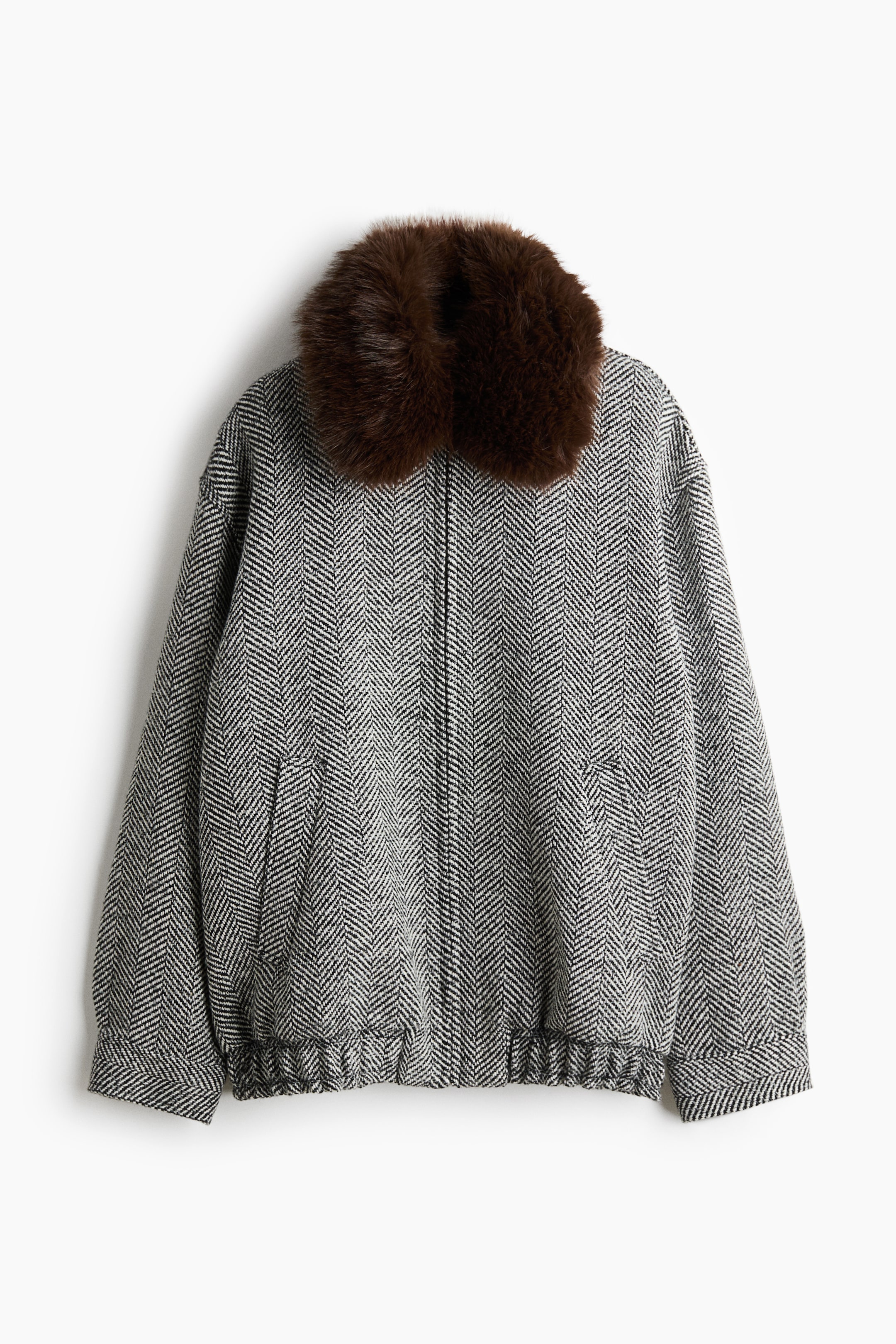 Ver imagen más grande: Una chaqueta de espiga en blanco y negro muestra un cuello afelpado de pelo sintético marrón en esta vista frontal. La chaqueta presenta un cierre delantero con cremallera oculta, bolsillos de ojal inclinados y un bajo elástico.