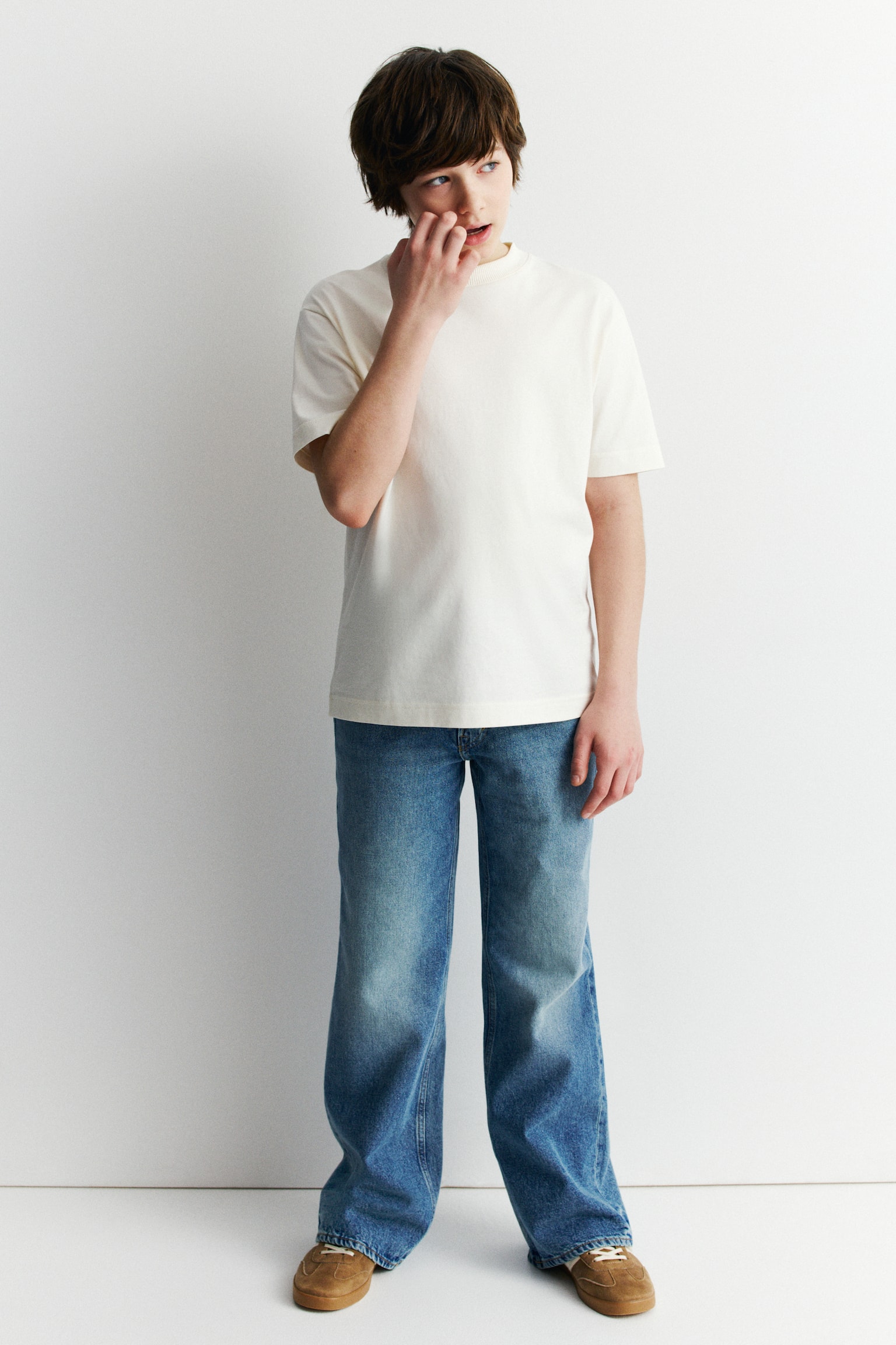 The 5-pocket jeans are shown from the front, showcasing a light to medium blue cotton denim. They are crafted with a relaxed fit through the hip, thigh, and leg, featuring a zip fly fastening with a button at the waist, and wide legs. - 1