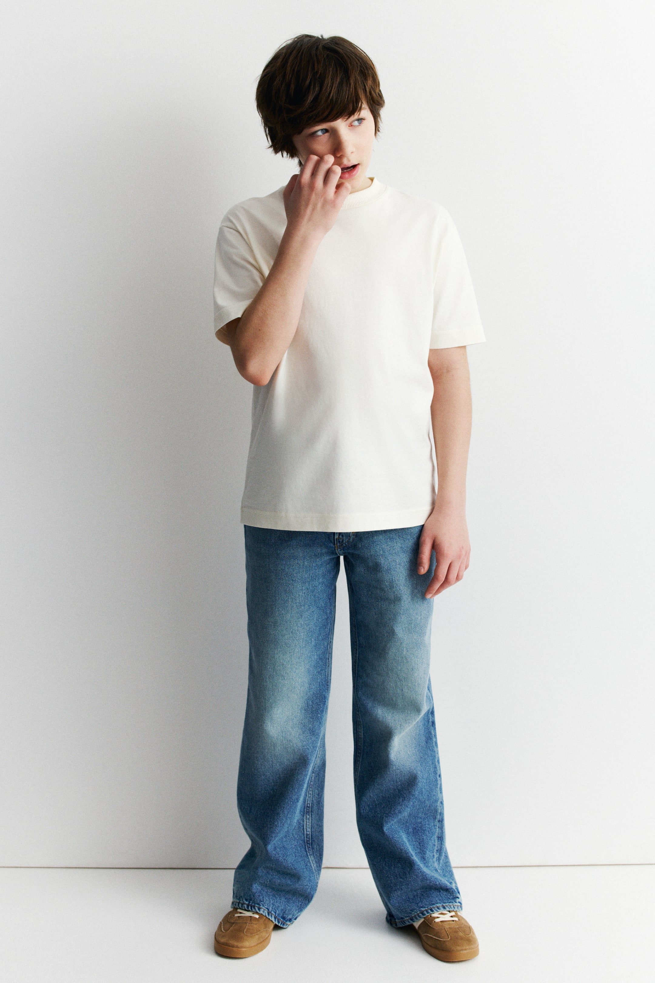 View larger image: The off-white t-shirt features a mock neck, short sleeves, and a relaxed fit. It displays a straight hem, with the front facing forward.