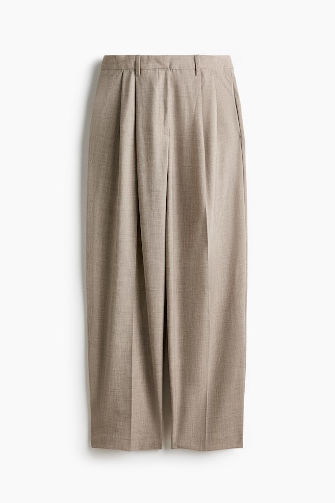 The pants showcase a light brown, subtly textured fabric, a flat waistband with belt loops, and prominent front pleats, offering a relaxed, straight-leg style from a front-facing perspective. - 1