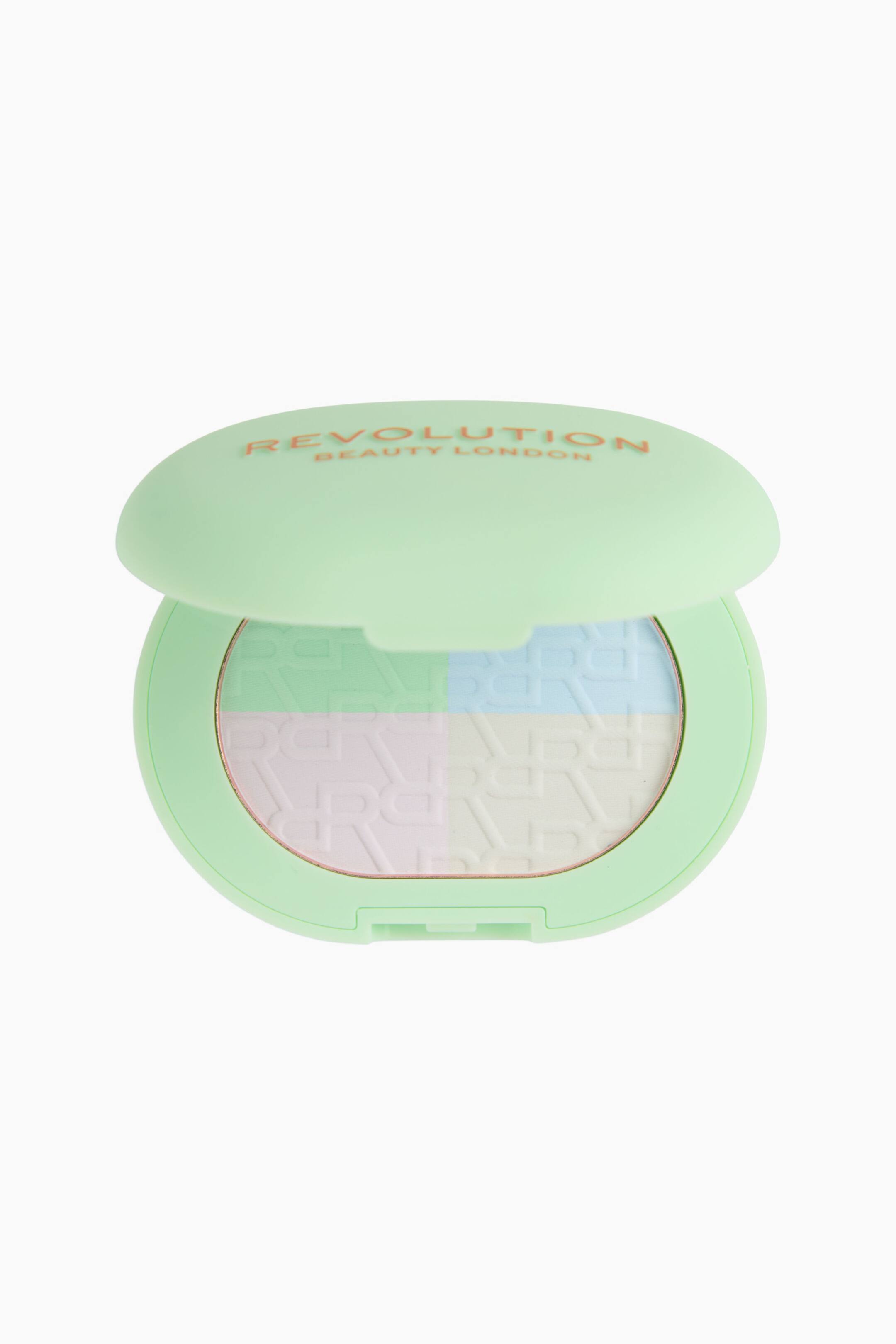 Visa större bild: Colour Correct Powder Pops-kompakten vilar i ett framåtriktat läge med locket delvis öppet, och visar ett ljus mintgrönt, ovalt etui. Öppningen avslöjar ett pressat puder uppdelat i fyra pastellfärgade kvadranter i grönt, blått, rosa och blekgult, där varje fält har ett präglat monogrammönster.