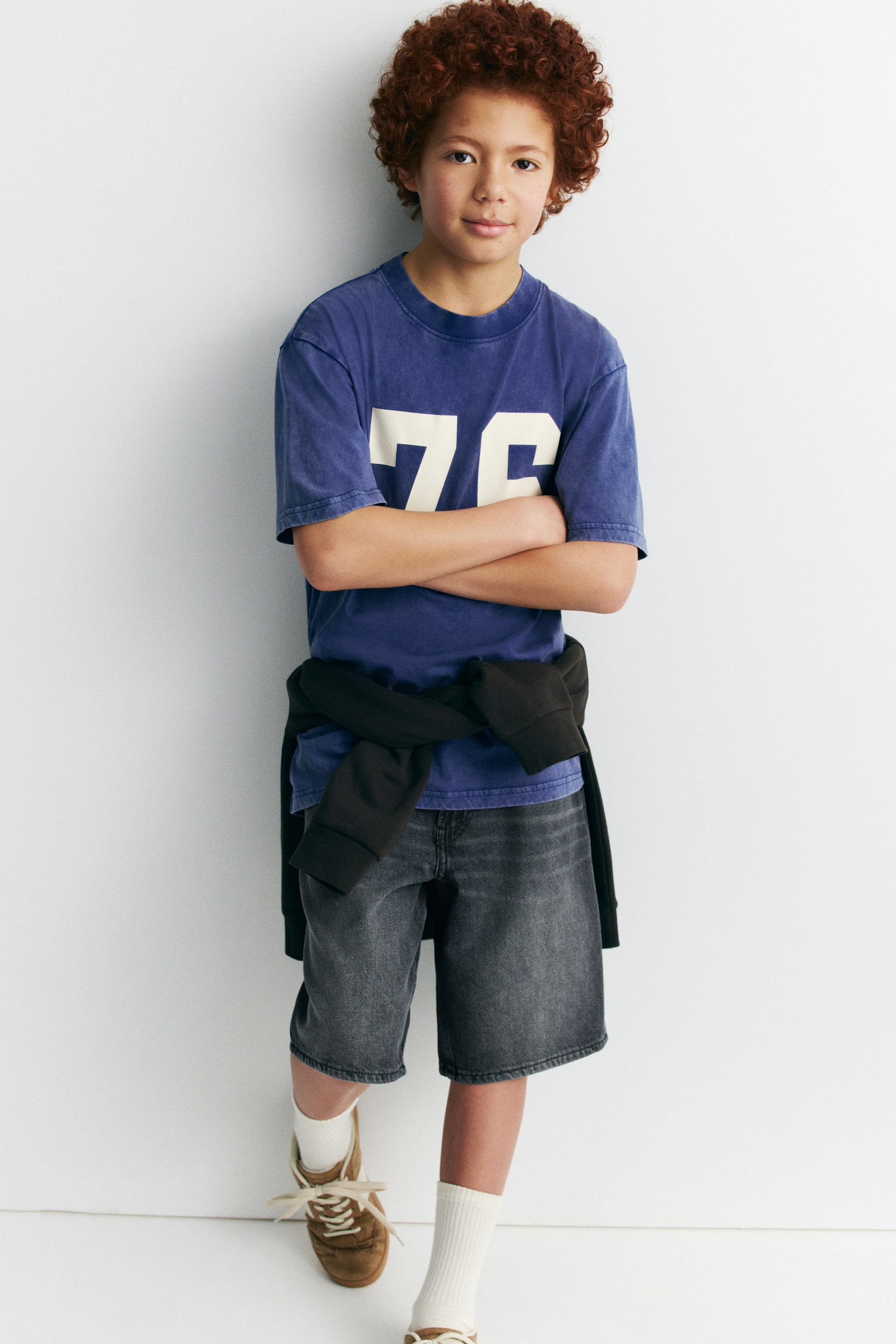 View larger image: A washed blue short-sleeved t-shirt with a ribbed crew neck and large white '76' numbers printed on the front.