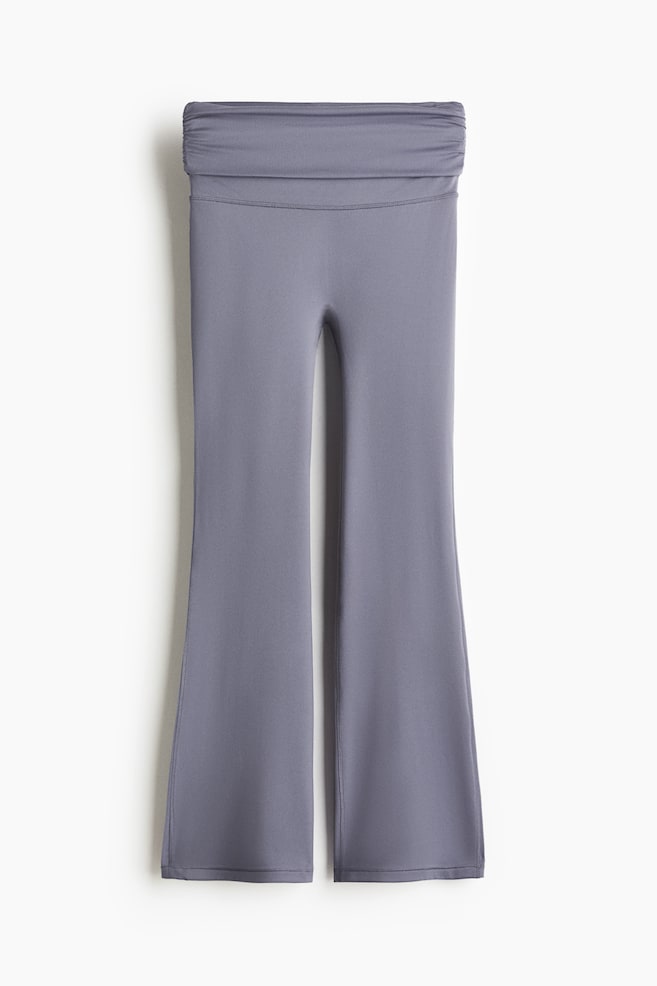 A pair of gray, flared-leg pants is presented from the front, featuring a wide, folded waistband with subtle ruching along the top edge and flatlock stitching visible along the side seams. - 1