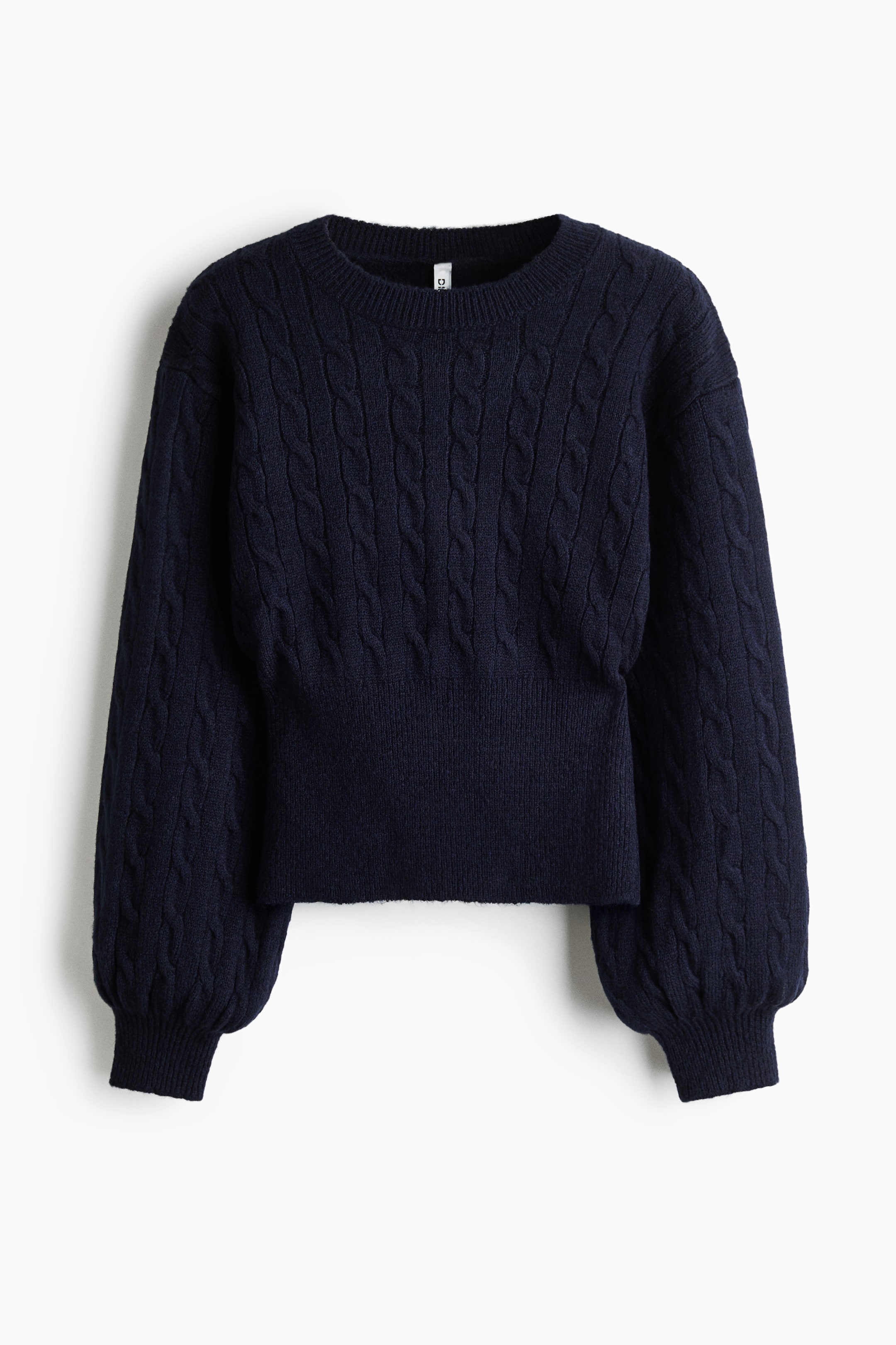 Größeres Bild ansehen: Ein marineblauer Zopfpullover wird von vorne gezeigt und verfügt über einen gerippten Rundhalsausschnitt, überschnittene Schultern sowie lange, voluminöse Ärmel mit gerippten Bündchen. Der Pullover zeigt ein vertikales Zopfmuster über dem Körper und den Ärmeln, das am Saum in einen breiten, gerippten Abschnitt übergeht.