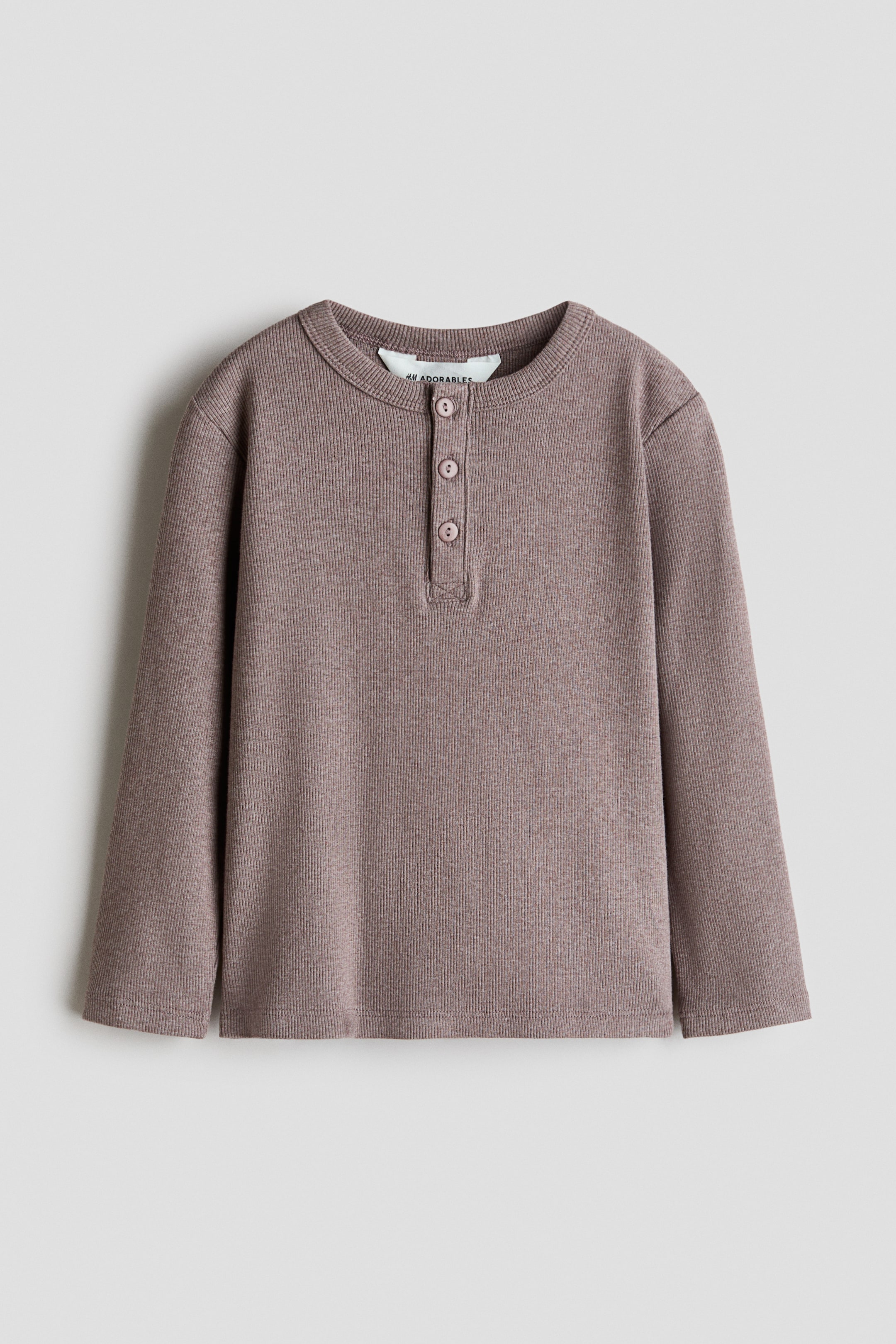 View larger image: A muted brown long-sleeved top, made of ribbed jersey, is lying flat, displaying its front, and featuring a round, rib-trimmed neckline with a three-button placket.
