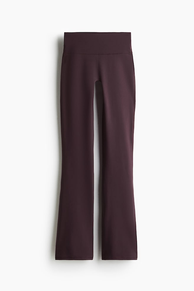 Flared sports leggings with SoftMove? are presented FRONT in a deep plum color, featuring a wide, smooth, high-rise waistband. The legs are fitting through the thighs and knees, flaring out from mid-calf to the hem, and are made from a smooth, matte fabric. - 1