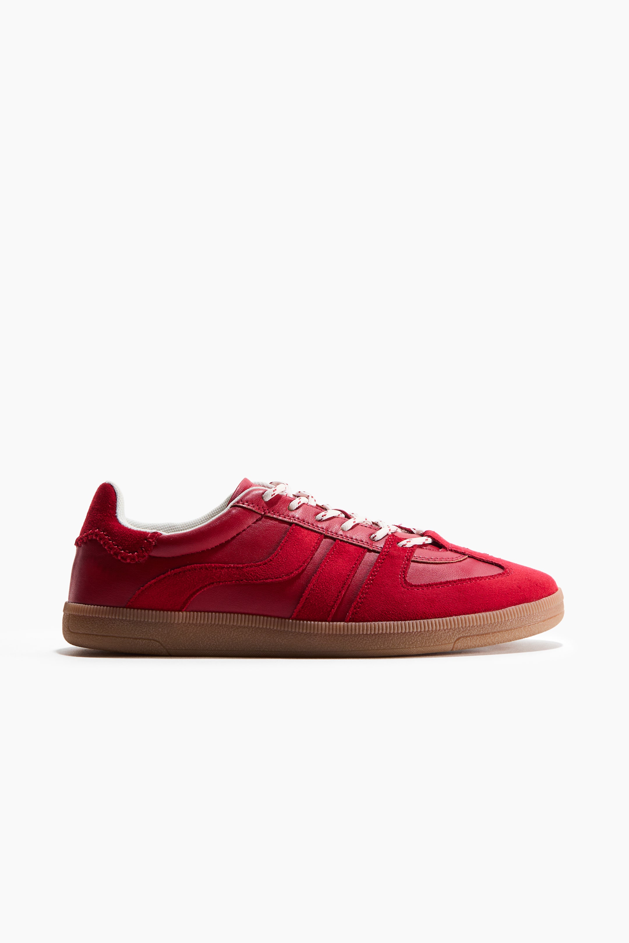 Visualizza immagine più grande: Le sneakers rosse a basso profilo sono mostrate in vista laterale, caratterizzate da un bordo superiore imbottito e lacci bianchi sul davanti. Sono realizzate con pannelli in pelle e camoscio rosso, poggiano su una suola in gomma alta 2,5 cm.