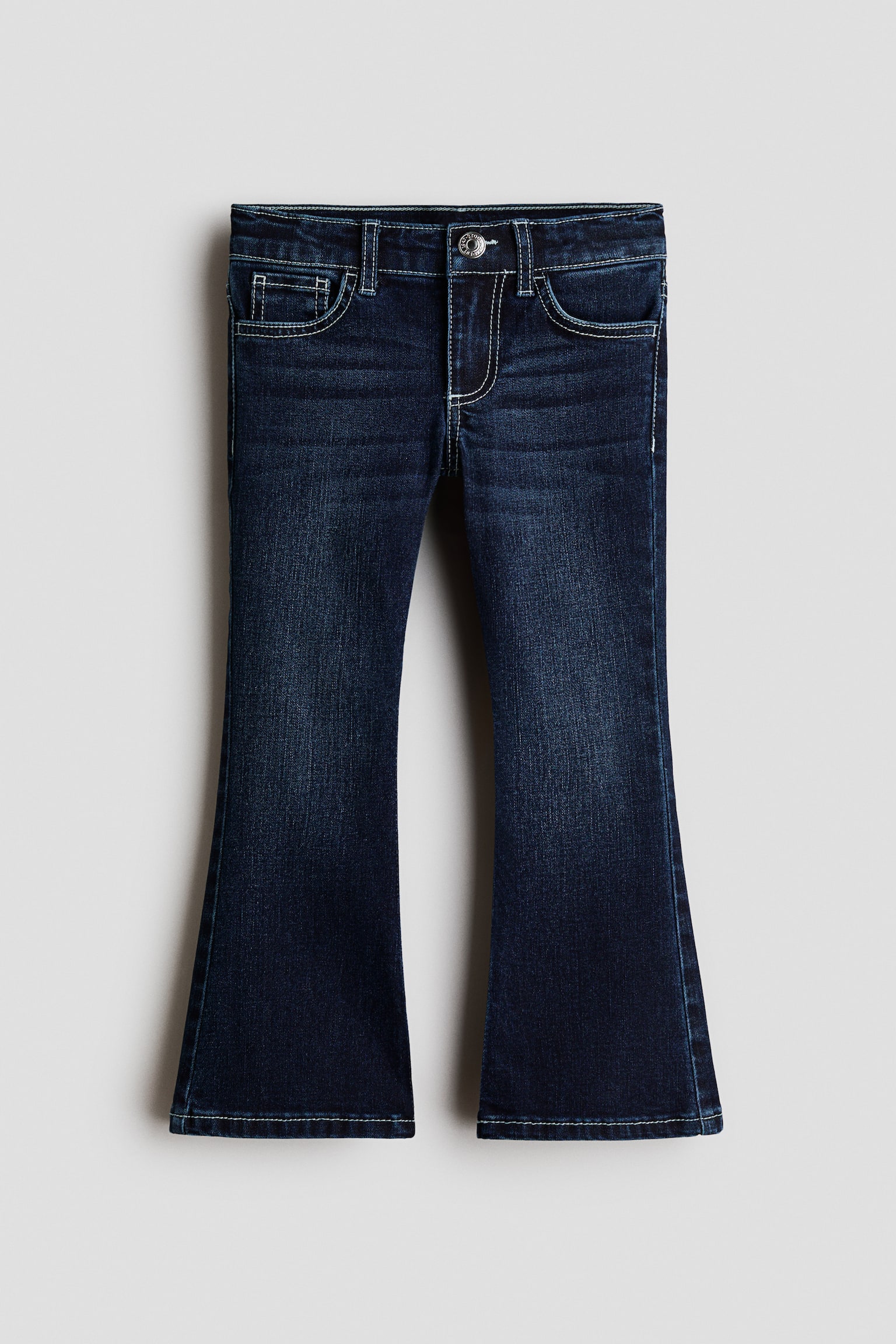 These dark wash flare jeans are shown from the front, featuring a classic five-pocket design with light-coloured contrast topstitching and a single metal button fastening. The denim shows subtle fading along the thighs before widening into a flared leg silhouette at the hem.