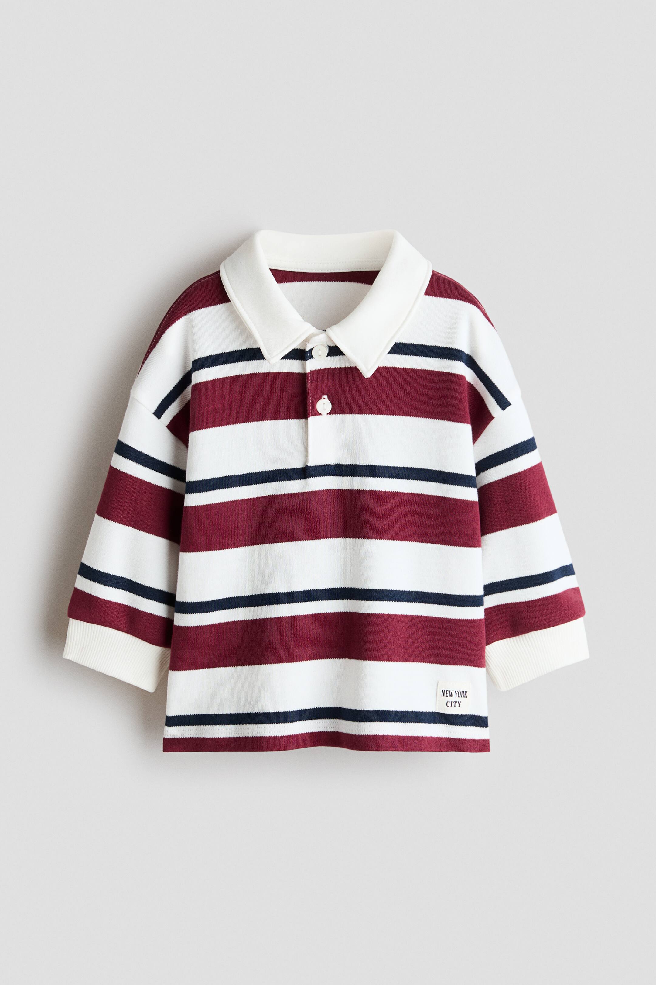 View larger image: A front-facing rugby shirt crafted from dense cotton jersey showcases horizontal white, maroon, and navy blue stripes. It features a white turn-down collar, a two-button placket, dropped shoulders, and long sleeves that finish with wide, ribbed cuffs, complemented by small slits at each side of the hem.