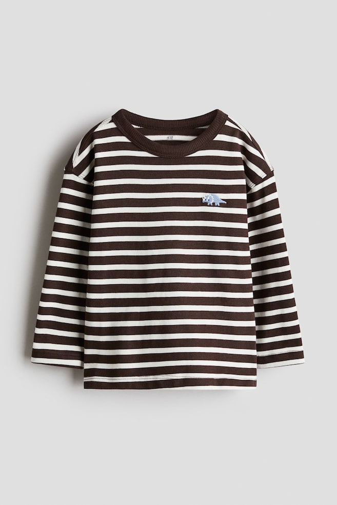 Front view of a long-sleeved shirt, featuring brown and white horizontal stripes, a ribbed crew neck, ribbed cuffs, and a small blue dinosaur embroidered on the left chest. - 1