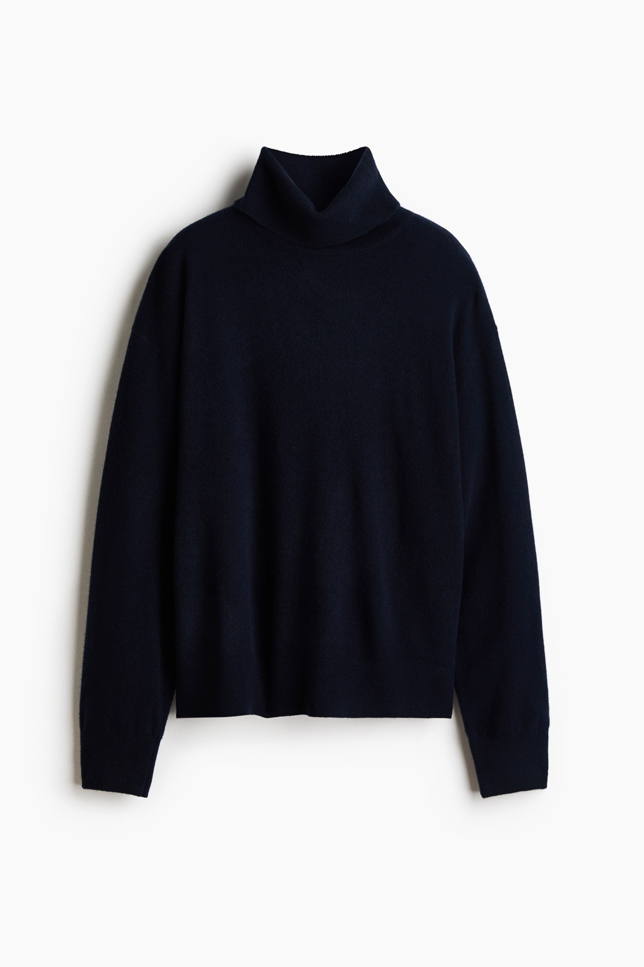Größeres Bild anzeigen: Ein oversized Feinstrickpullover aus Kaschmir in Dunkelmarine ist von vorne zu sehen, mit einem dicken, gerippten Rollkragen, überschnittenen Schultern und langen Ärmeln mit gerippten Bündchen.