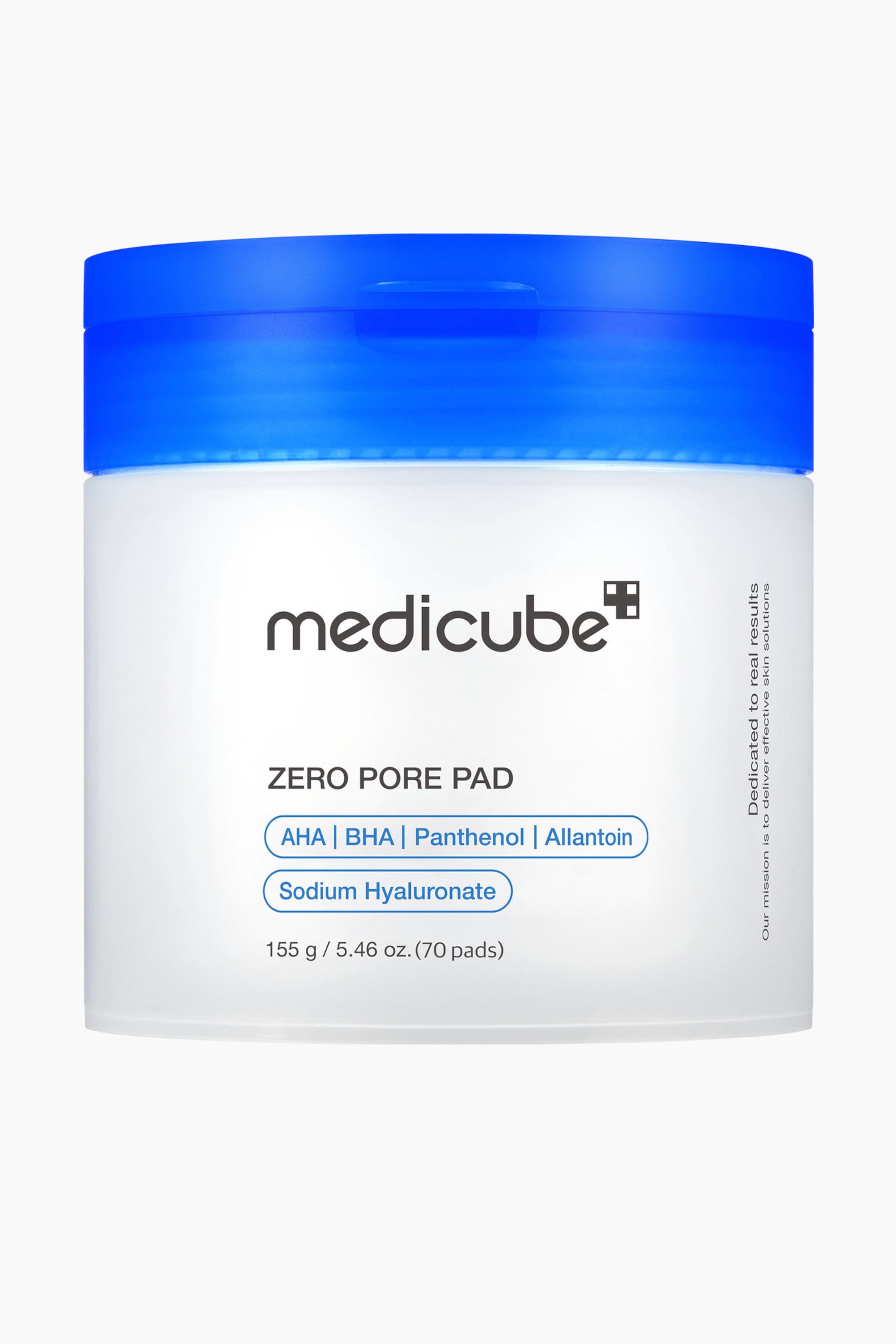 Visa större bild: En behållare med Medicube Zero Pore Pad står upprätt och har en vit, ogenomskinlig kropp med ett genomskinligt blått lock. Framsidans etikett visar "medicube" och "ZERO PORE PAD," tillsammans med "AHA | BHA | Panthenol | Allantoin" och "Sodium Hyaluronate" i blått inramade ovaler, samt mängden "155 g / 5,46 oz. (70 pads)." Vertikal text på höger sida lyder "Dedicated to real results Our mission is to deliver effective skin solutions."