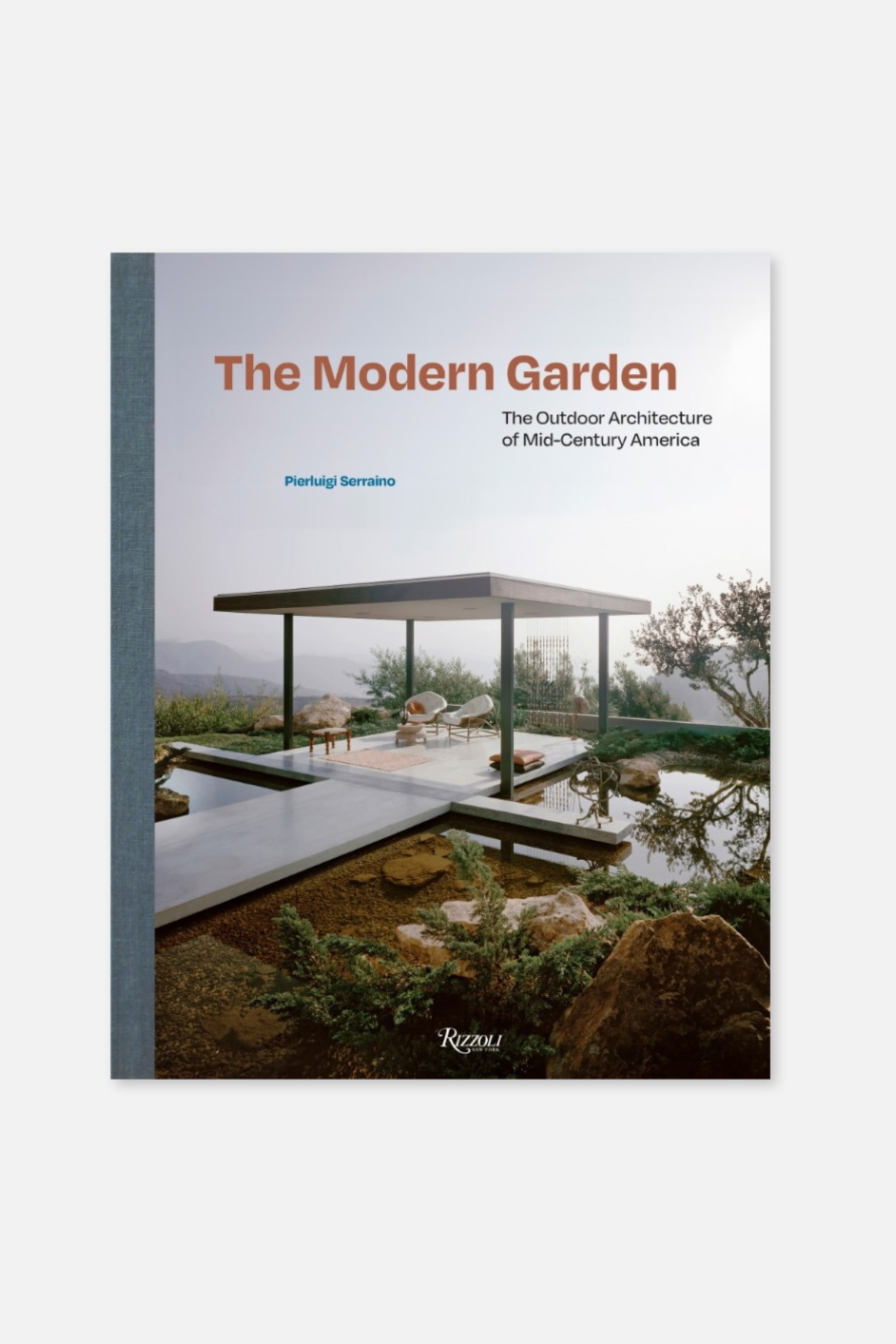 Agrandir l'image: Le livre "The Modern Garden: The Outdoor Architecture of Mid-Century America" de Pierluigi Serraino est légèrement incliné vers l'avant et la droite, sa couverture représentant un espace de vie extérieur moderne avec une terrasse couverte, des éléments aquatiques et un aménagement paysager naturel. Une tranche texturée gris foncé est visible à gauche, et le logo Rizzoli New York est imprimé en bas à droite de la couverture.
