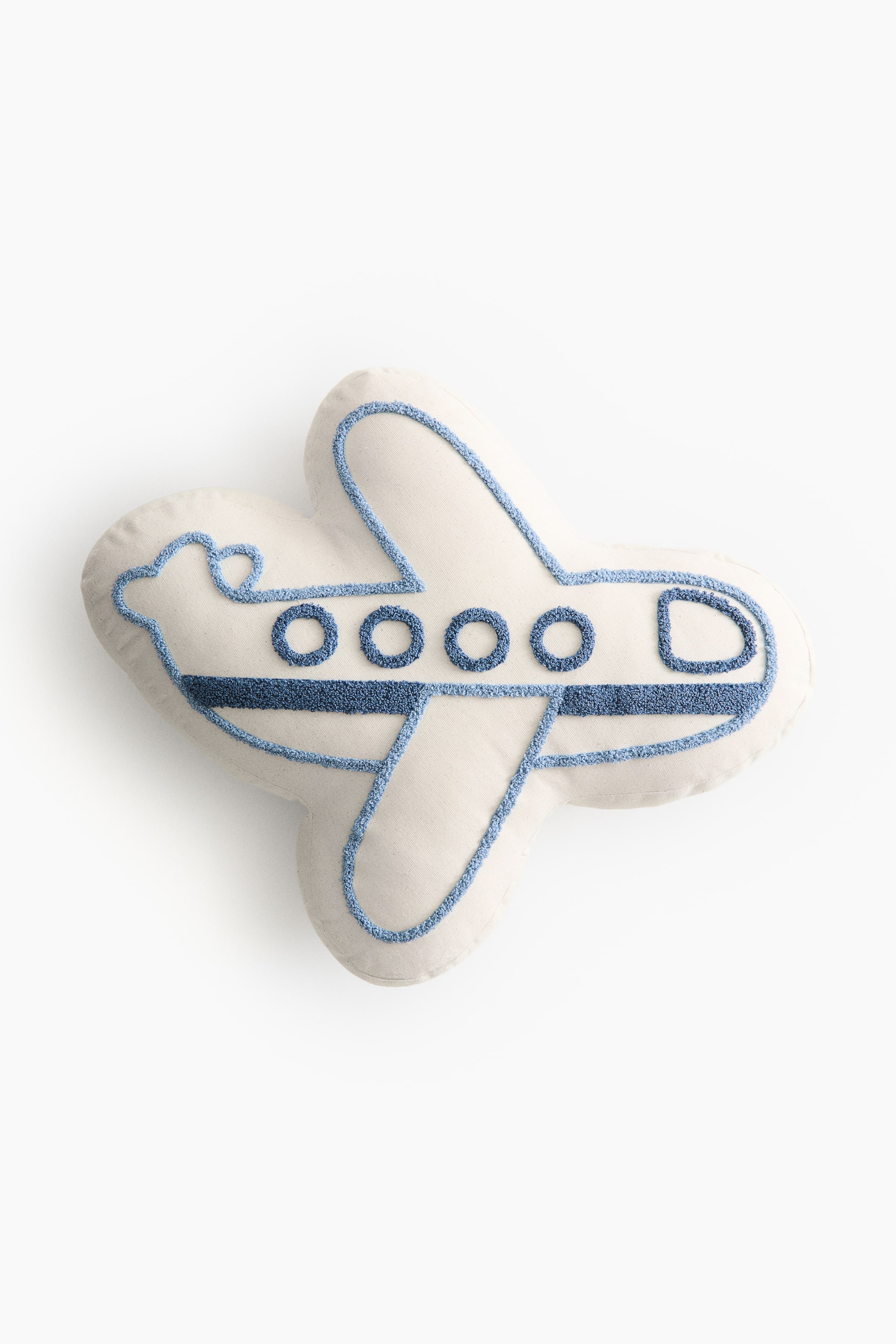 View larger image: An airplane-shaped pillow features an off-white fabric with blue textured embroidery outlining its form. It displays circular windows, a D-shaped cockpit window, and a stripe along the fuselage, all rendered in blue textured embroidery.