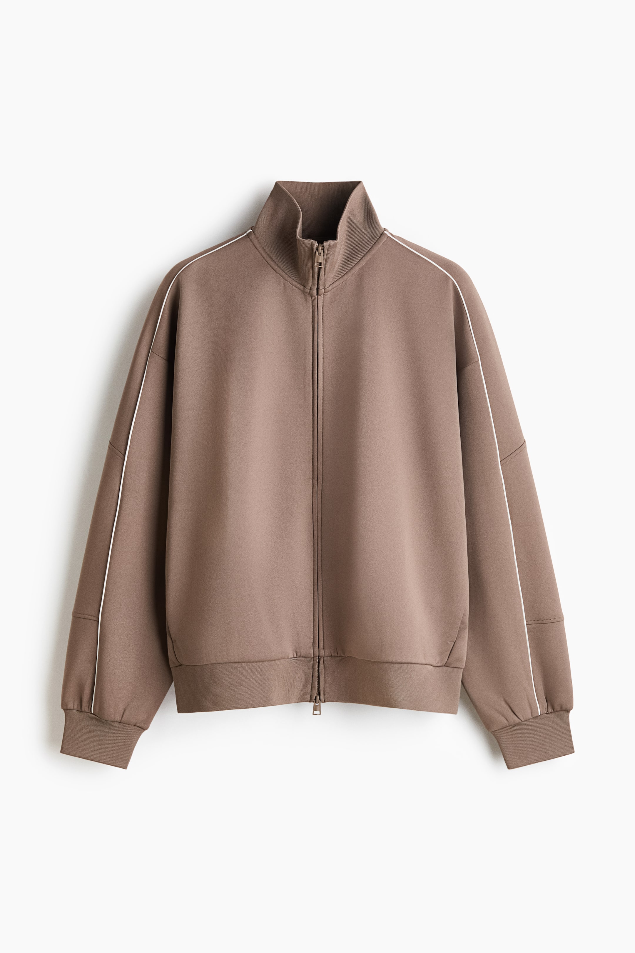 View larger image: A brown zip-up track jacket is shown from the front, featuring a high stand-up collar, dropped shoulders, and a full-length front zipper. Thin white piping runs along the shoulder seams and down the sleeves, which finish with ribbed cuffs and a matching ribbed hem.