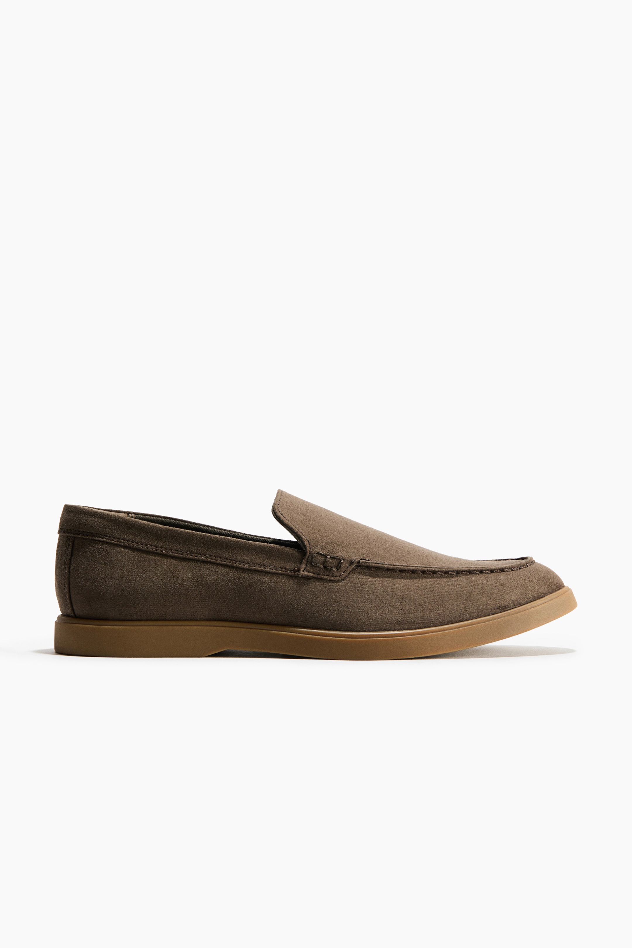 View larger image: A brown loafer with a soft, napped finish is resting in side profile, showcasing a moccasin seam at the front and a flat, tan-coloured sole.