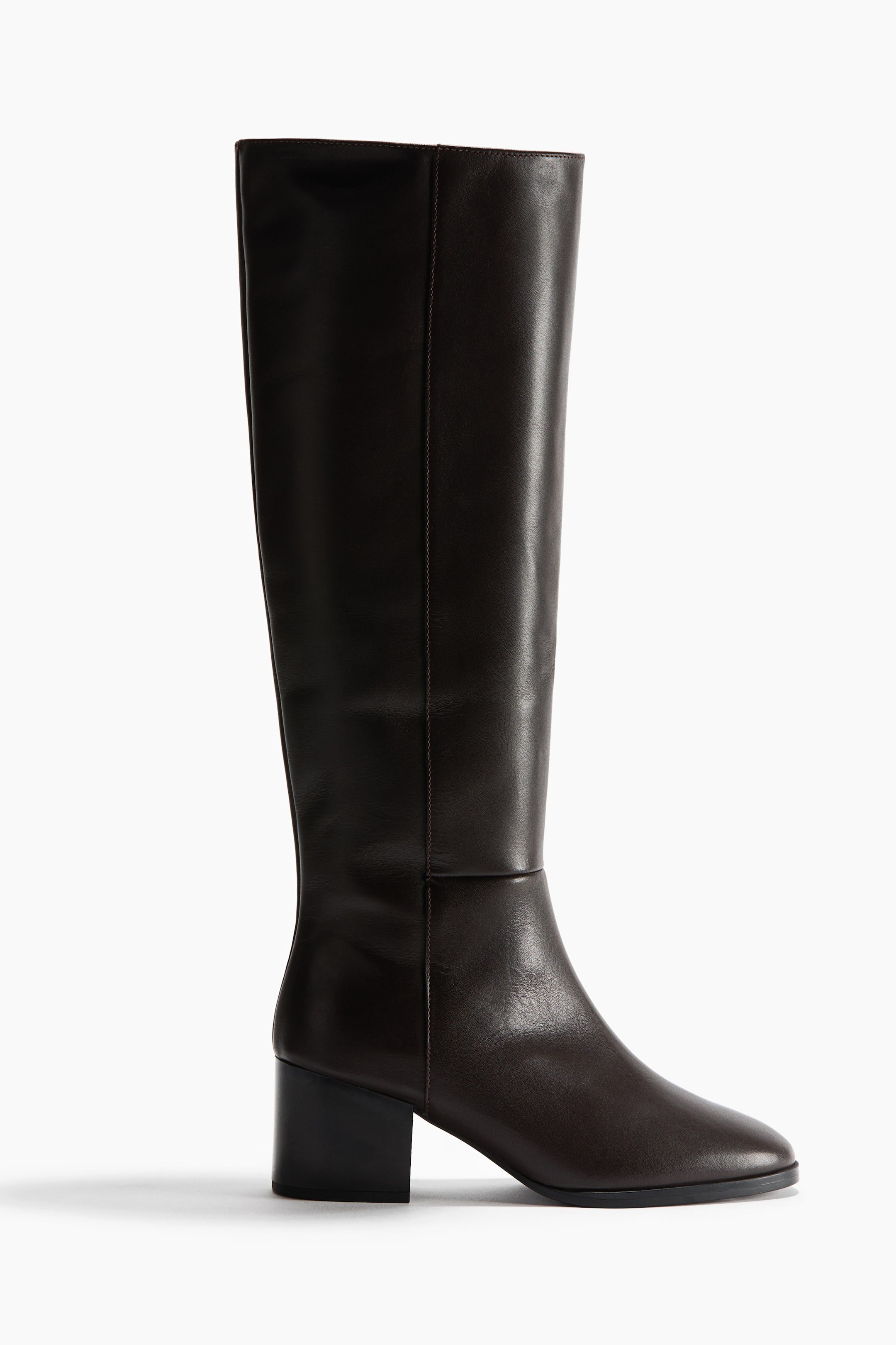 View larger image: A dark brown leather knee-high boot is shown in side profile, featuring a rounded toe, a low block heel, and a smooth finish. A vertical seam runs up the side of the shaft, defining its structured silhouette.