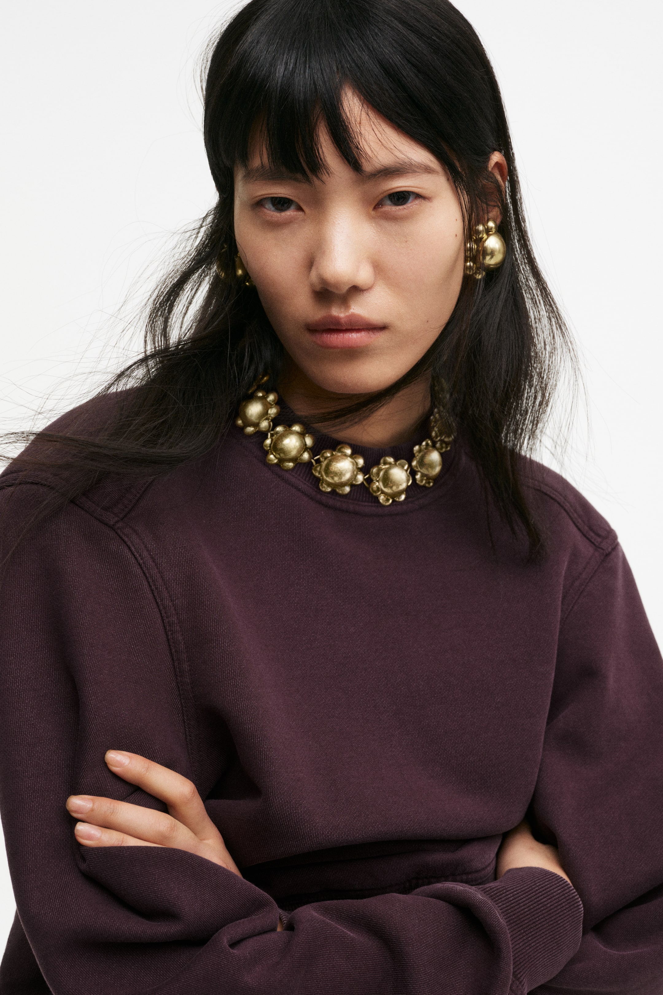 Grotere afbeelding bekijken: Een pruimen crew neck sweatshirt wordt gepresenteerd vanuit een licht schuin vooraanzicht, met een gewassen afwerking, raglanmouwen met zichtbare stiksels, geribbelde boorden, een geribbelde zoom en een ontspannen pasvorm.