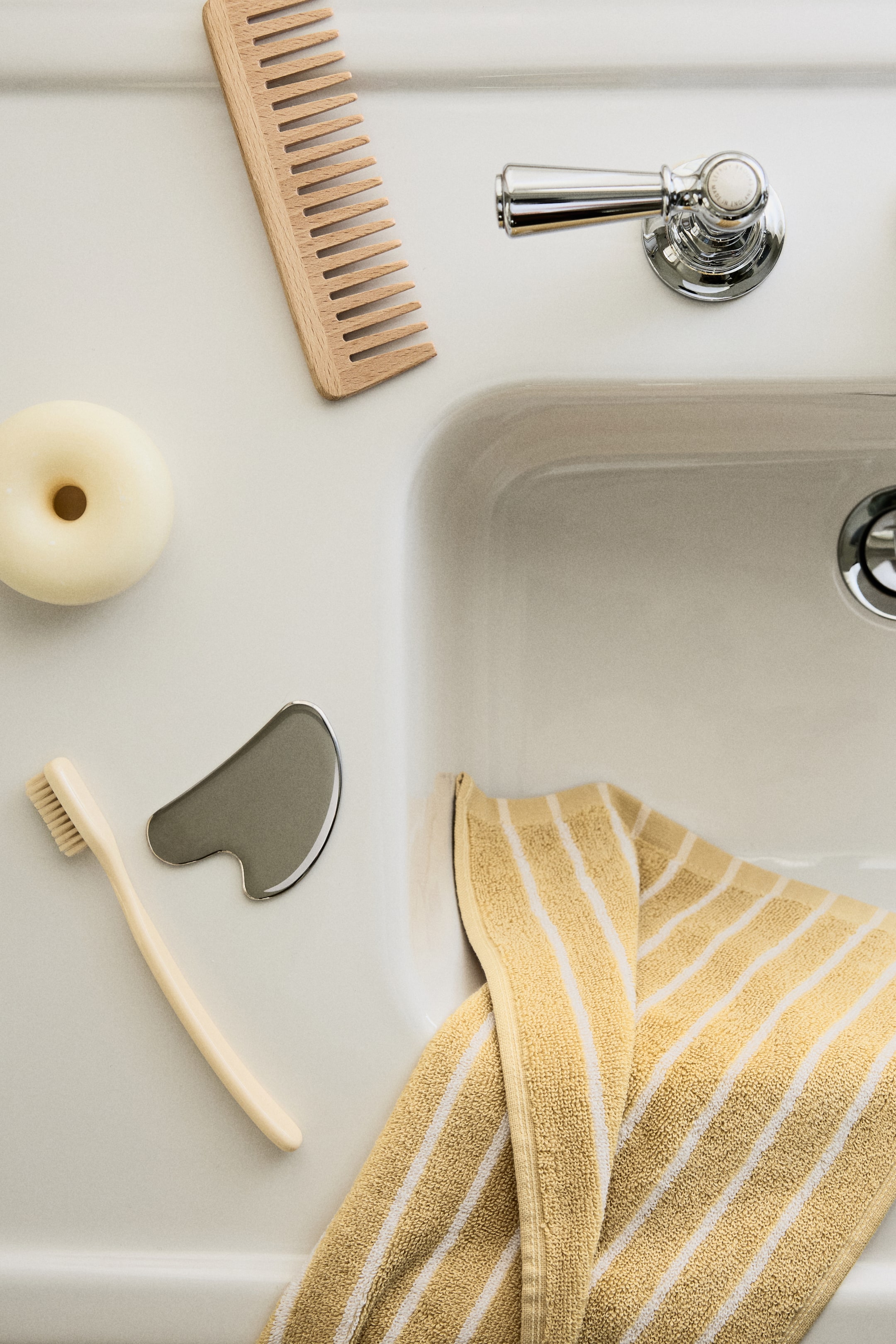 Ver imagen más grande: Una toalla de invitados de suave rizo de algodón está doblada, con rayas teñidas en hilo amarillo y blanco en su superficie FRONTAL.