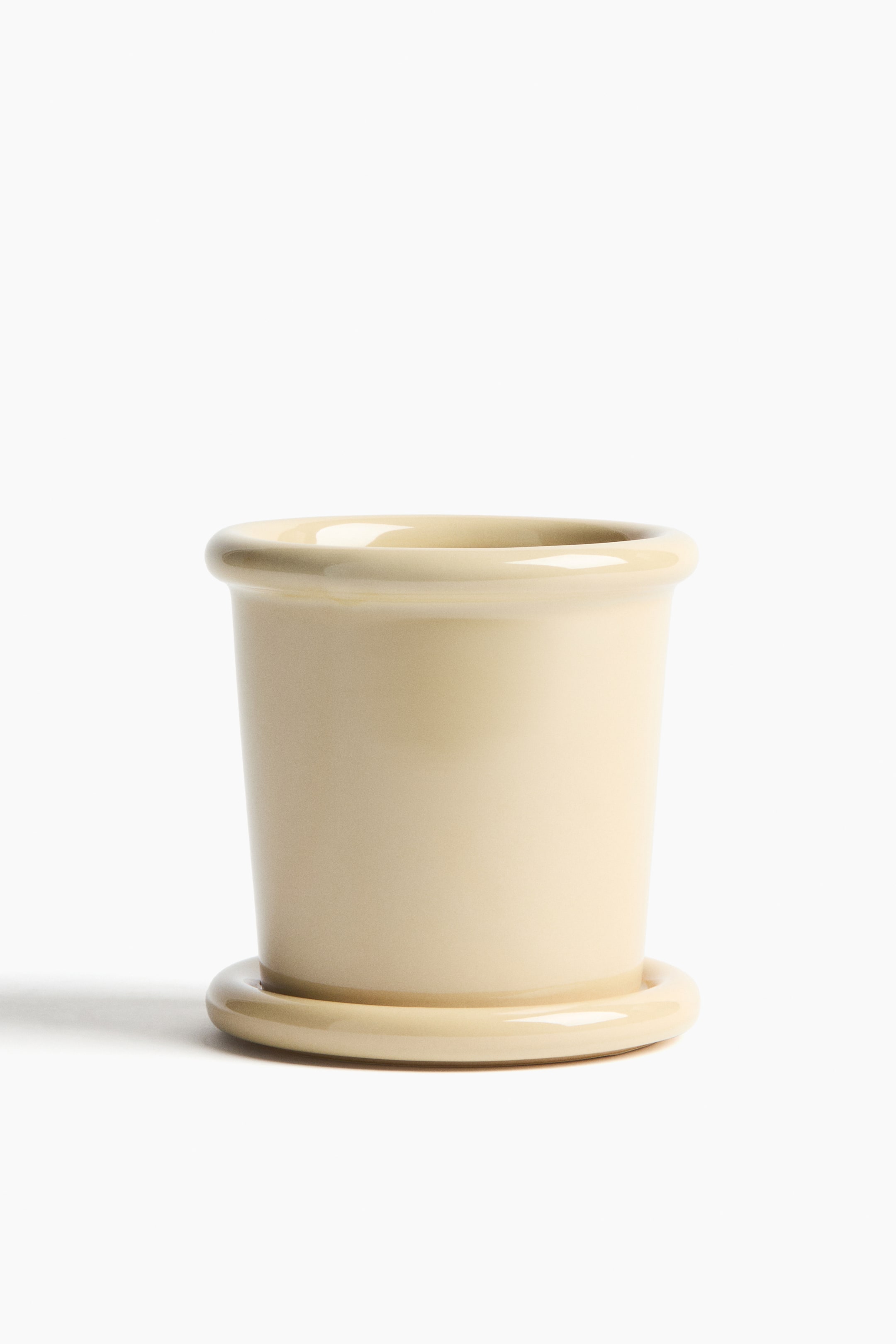 View larger image: An extra-small, light beige plant pot in glazed stoneware is presenting on the front, featuring a cylindrical body with a rounded rim and a matching saucer sitting directly beneath it.