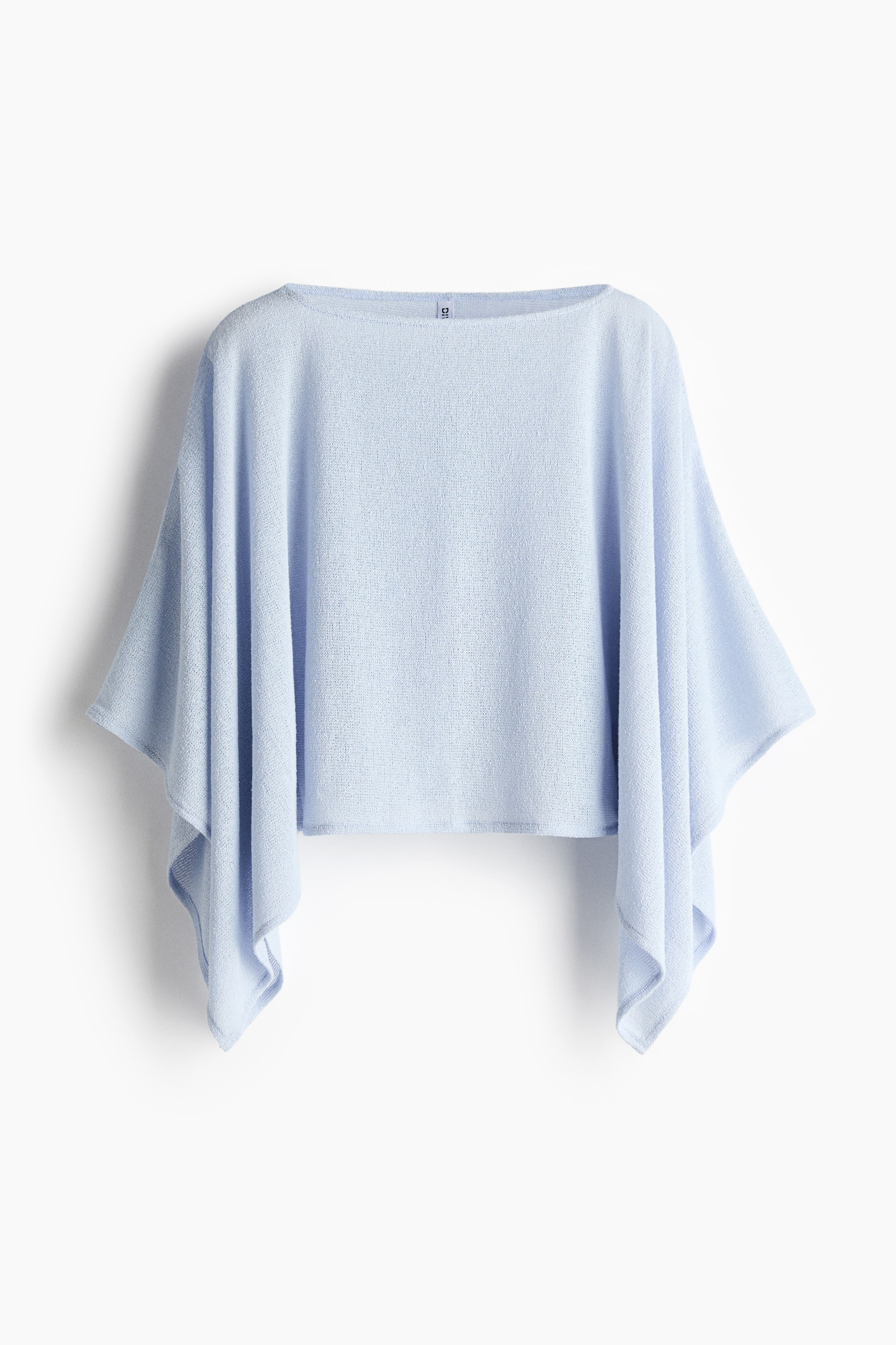 View larger image: The light blue, loose-fit top, viewed from the FRONT, showcases a soft, textured knit and a boat neckline. Wide cape sleeves flow freely from the sides, contributing to its relaxed silhouette.