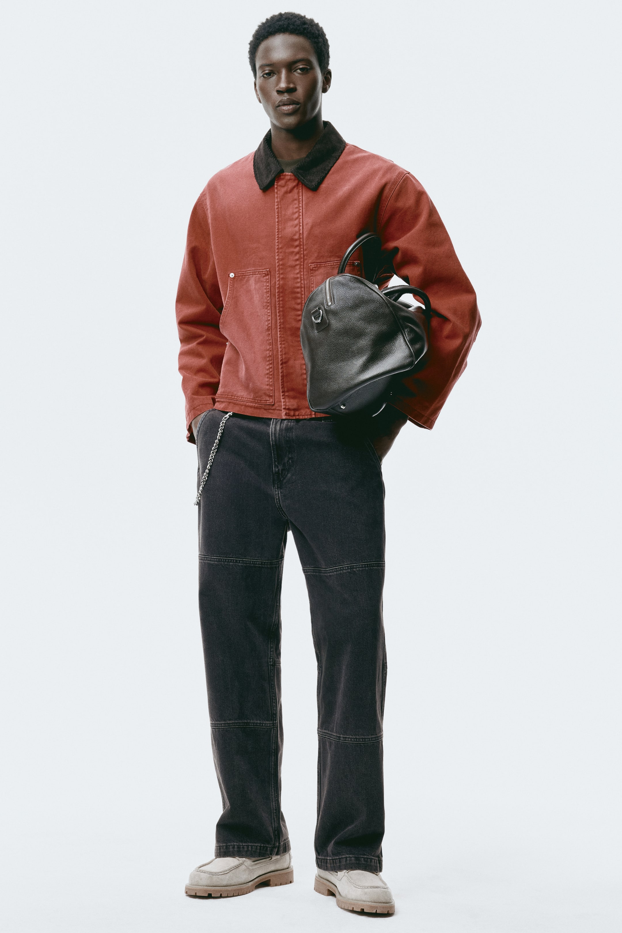 Xem ảnh lớn hơn: Quần jeans denim màu đen có phom relaxed, straight-leg, với các đường may ngang và dọc nổi bật, tạo nên thiết kế ghép mảng (paneled) trên ống quần.