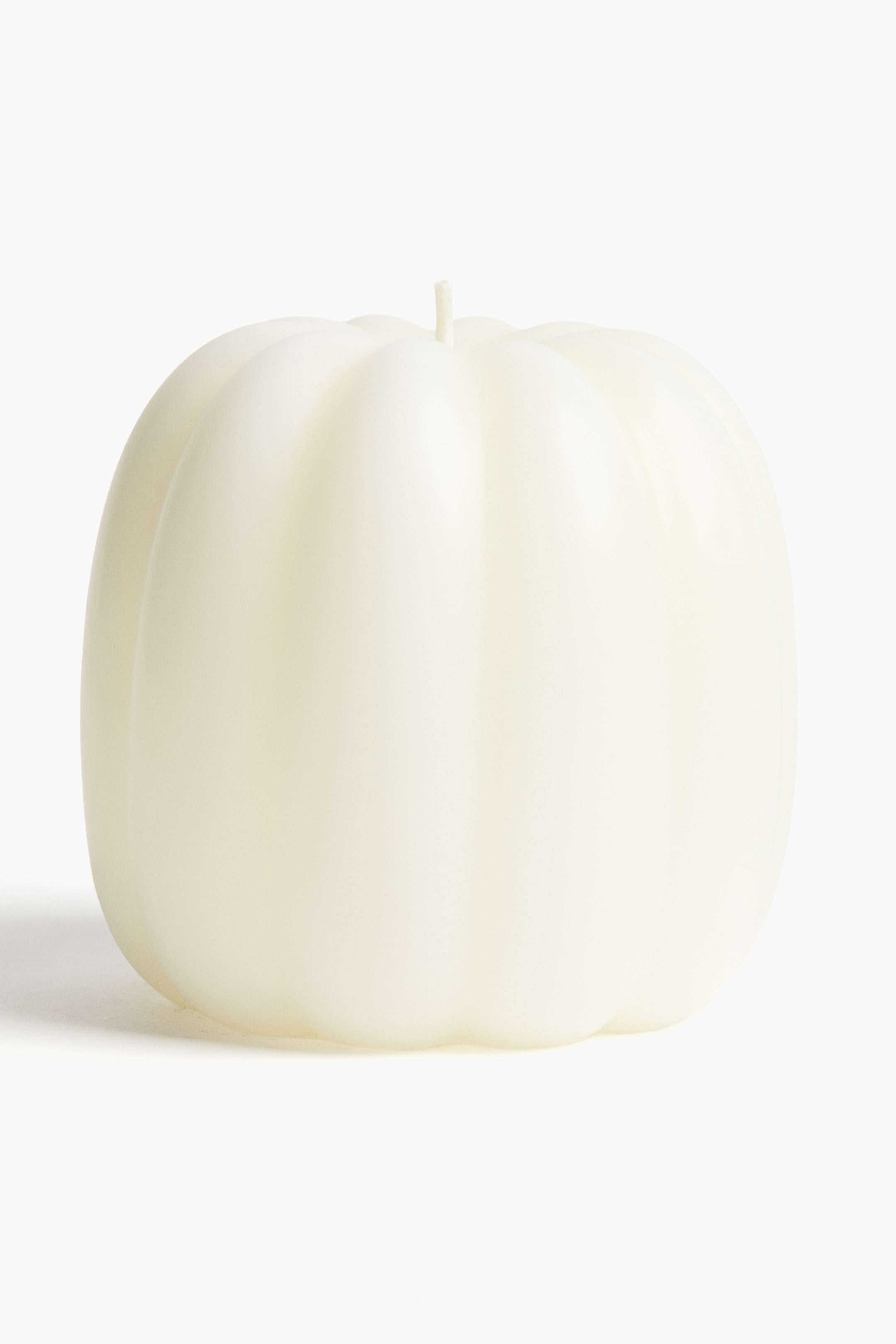 View larger image: A cream-colored, pumpkin-shaped candle features vertical ridges, with a single wick protruding from the center of its top.