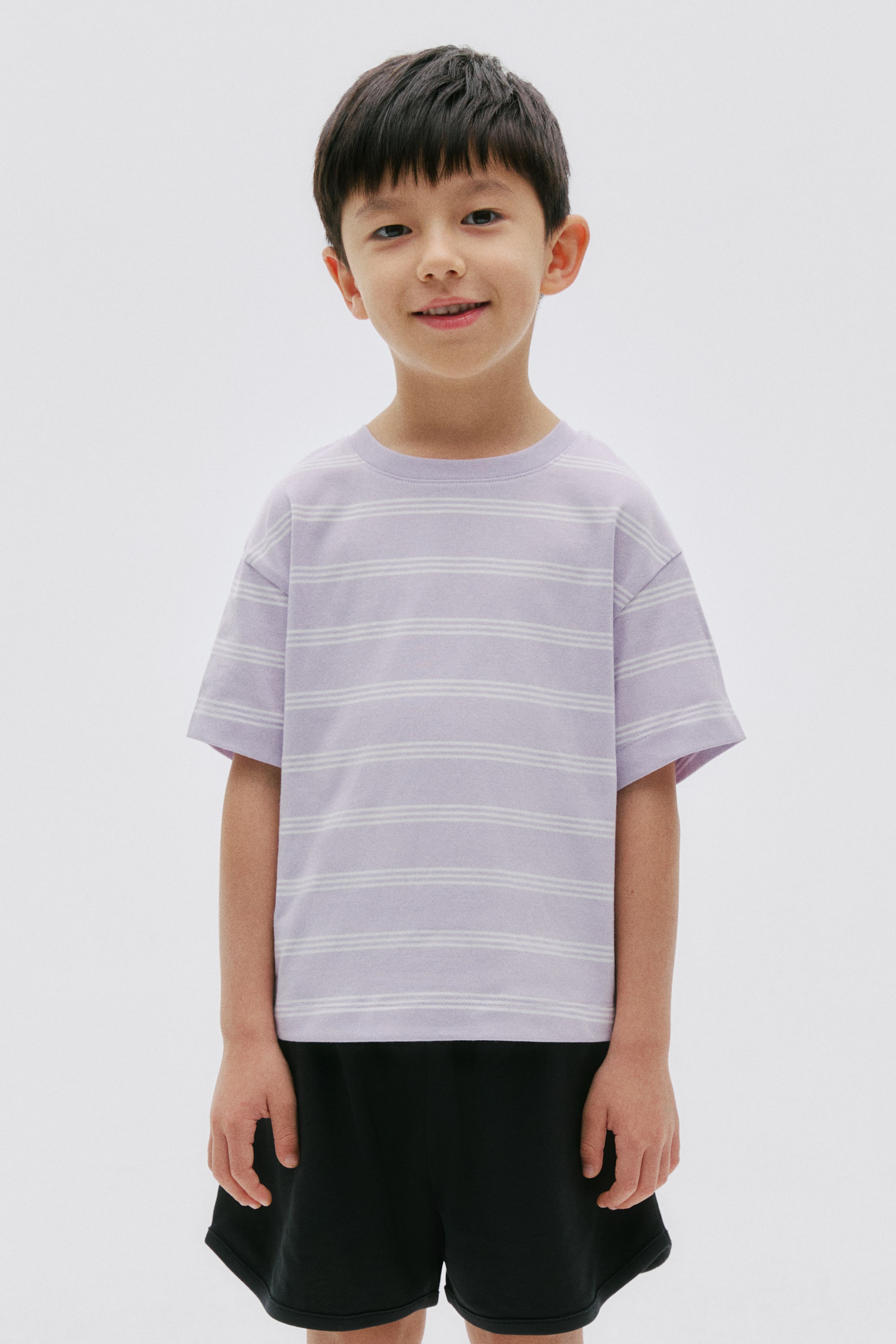 View larger image: A light purple t-shirt is displaying horizontal white stripes grouped in sets of three. It is designed with a crew neck and short sleeves, with a relaxed fit, and is facing forward.
