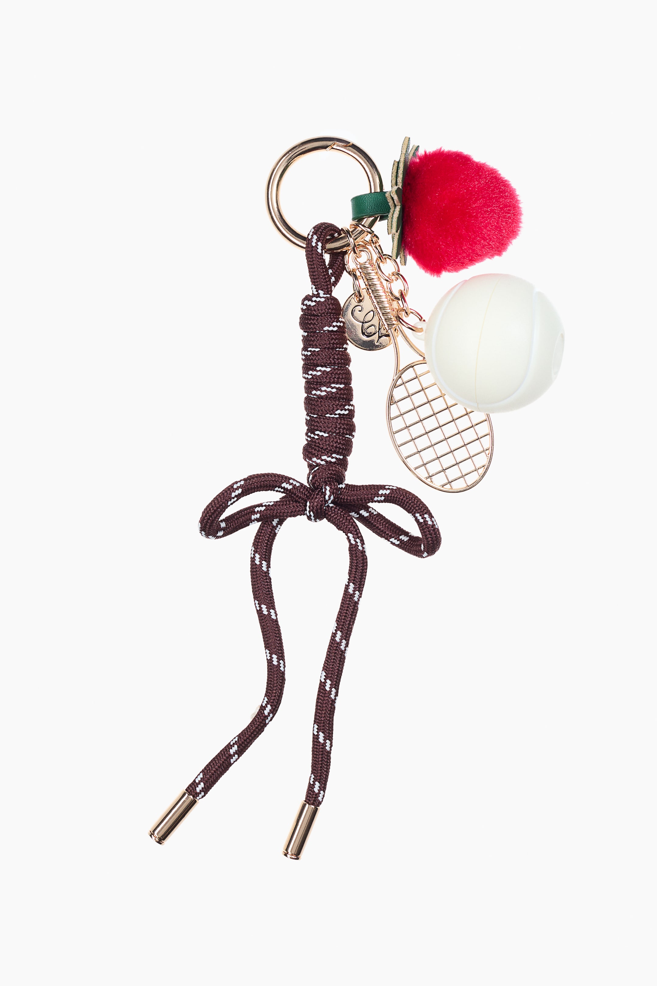View larger image: The bag charm features a gold-toned metal clasp, from which a red fluffy pom-pom strawberry with green leaves, a creamy white container designed as a tennis ball, a gold-toned tennis racket pendant, and small circular and spring-shaped charms are hanging. A dark brown braided cord with white flecks is also attached, forming a decorative knot and ending in gold-toned tips.
