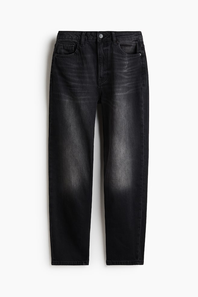Showing a front view, these high-waisted, five-pocket jeans in faded black denim are featuring a slim fit that tapers toward the hems. The jeans are displaying subtle whiskering near the waist and prominent fading along the thighs, complete with belt loops and a metal button closure. - 1