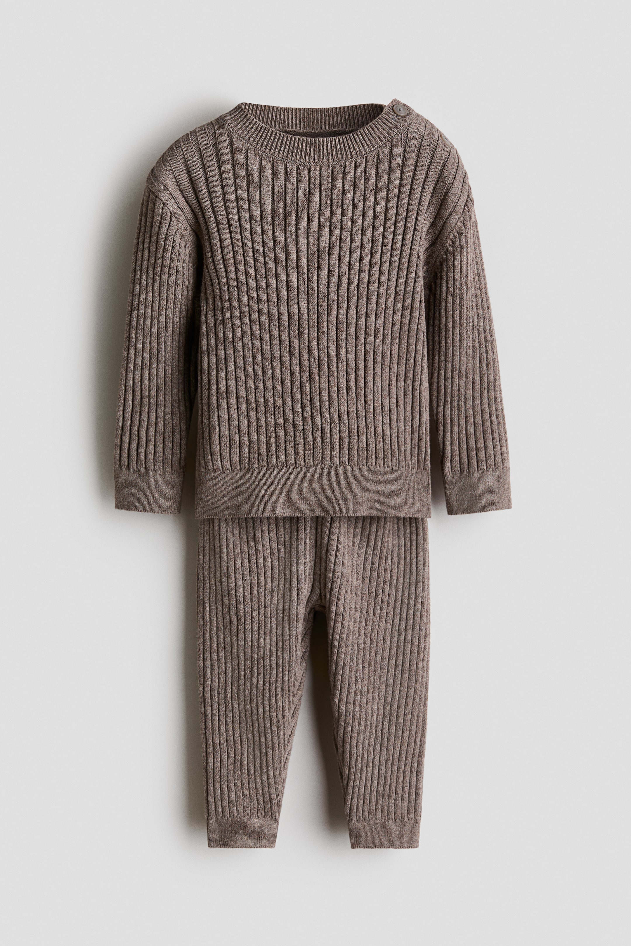 Agrandir l'image: Un ensemble bébé en tricot côtelé brun chiné comprenant un haut à manches longues avec un col rond, deux boutons à l'épaule, des poignets côtelés et un ourlet côtelé, accompagné d'un pantalon côtelé assorti à longueur complète avec des poignets côtelés aux chevilles.