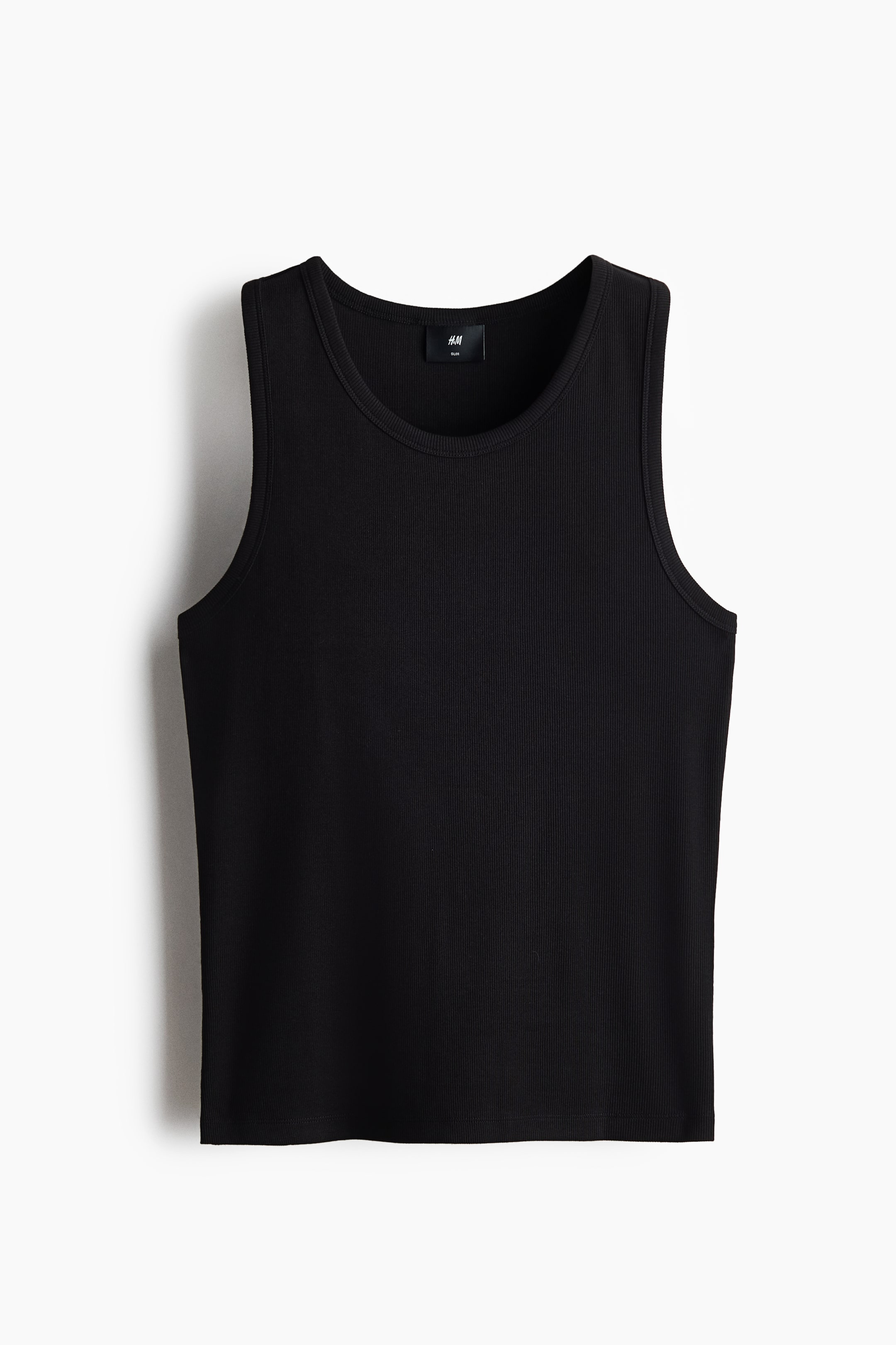 View larger image: A black ribbed tank top is shown from the front. It features a round neckline, a straight hem, and a black brand label with white text visible on the inside of the back neckline.