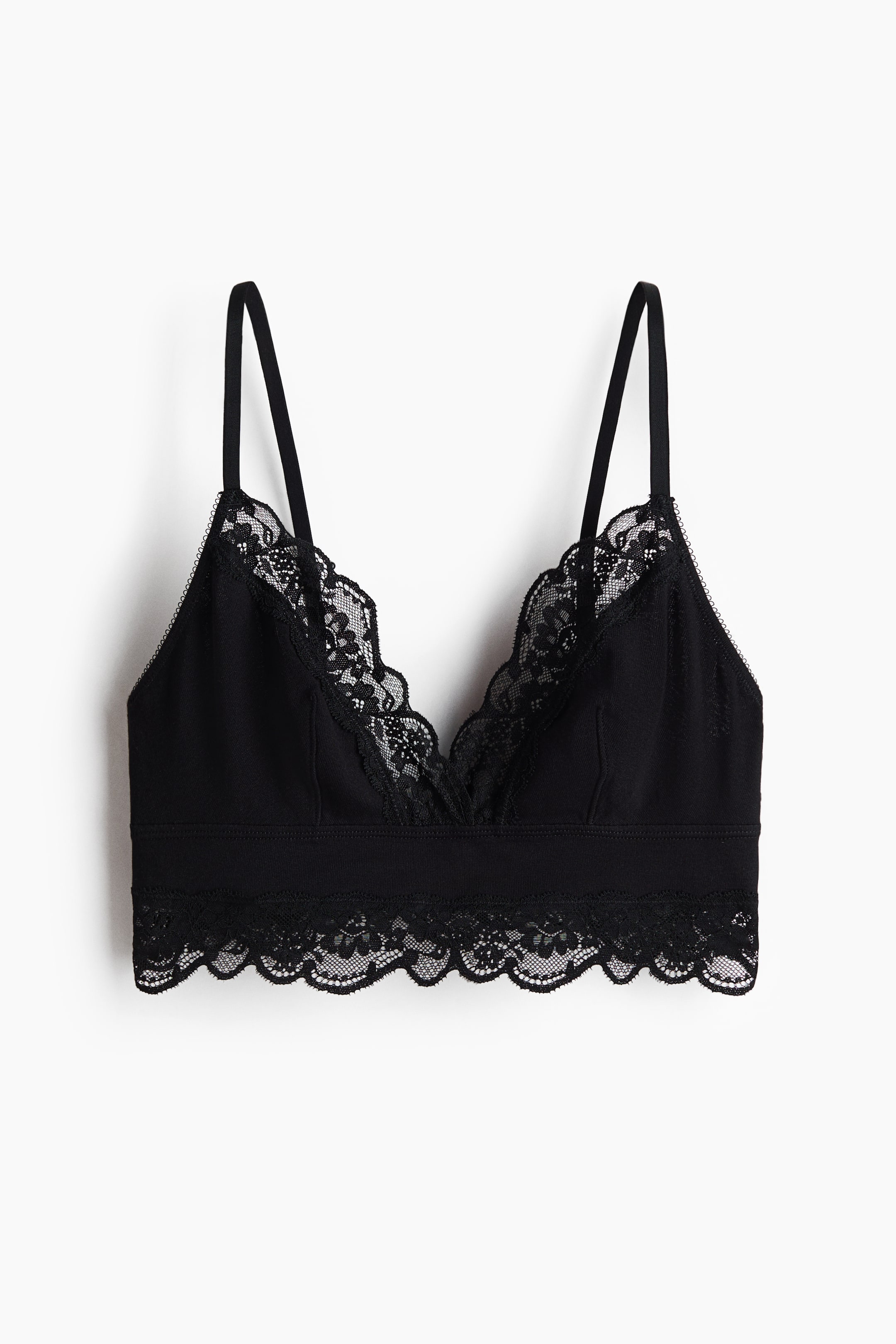 View larger image: A black bralette featuring a V-neckline with scalloped lace trim and thin shoulder straps. Its wide underbust band transitions into a matching scalloped lace border along the bottom.