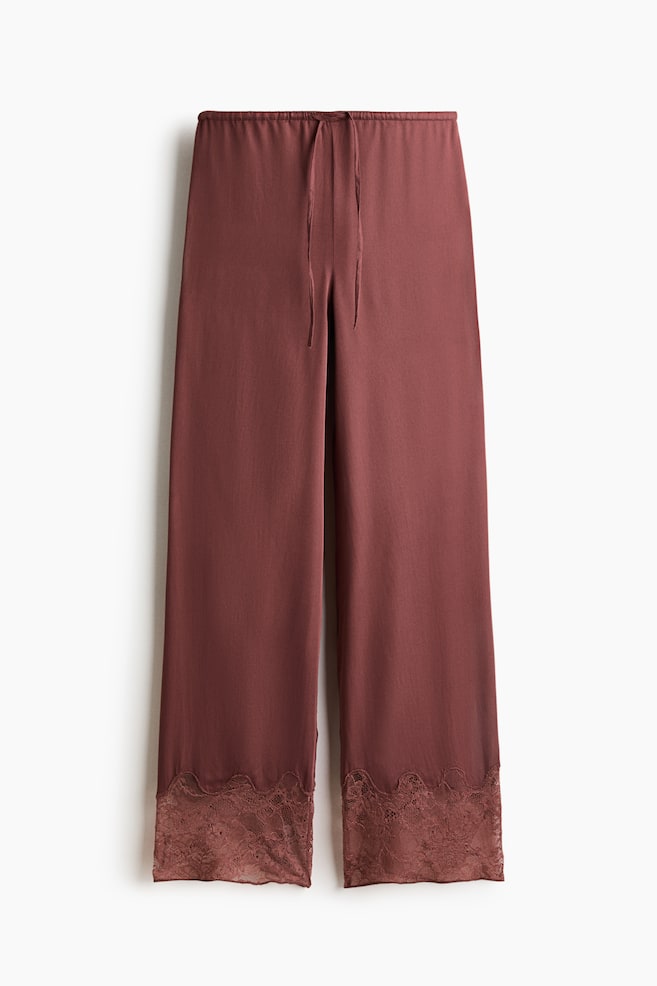 Pyjama bottoms in a muted reddish-brown colour are crafted from softly draping viscose satin. They feature an elasticated waistband with a drawstring, complemented by wide lace trim adorned with a floral pattern and scalloped edges at the hems. - 1