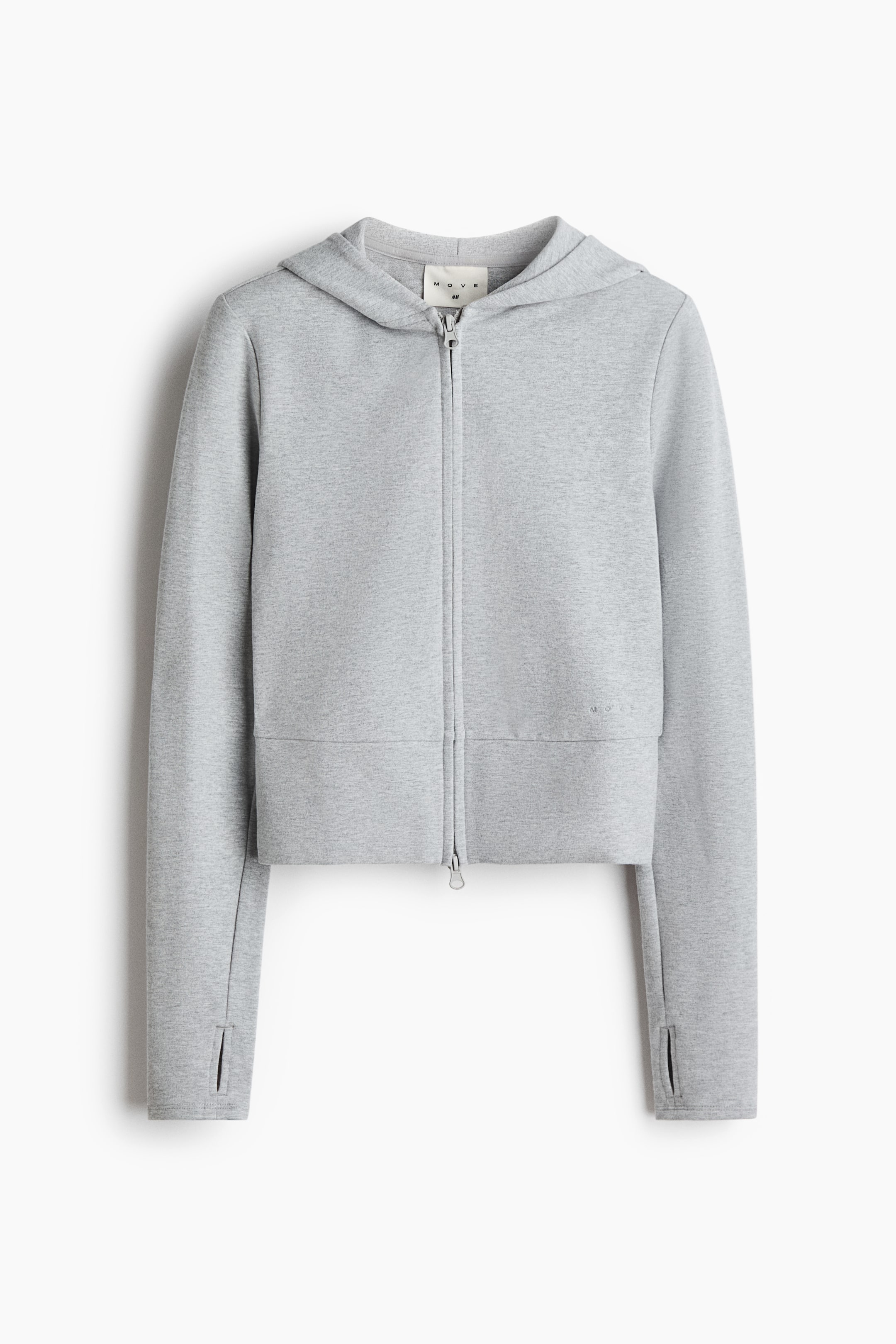 Xem ảnh lớn hơn: Một áo hoodie cropped kéo khóa màu xám nhạt melange được chụp ở góc nhìn chính diện, có mũ liền thân, khóa kéo hai chiều phía trước và tay dài với bo tay có lỗ luồn ngón cái. Thiết kế gồm phần gấu áo bản rộng dạng panel và chi tiết branding tông màu tinh tế ở phía dưới bên trái.