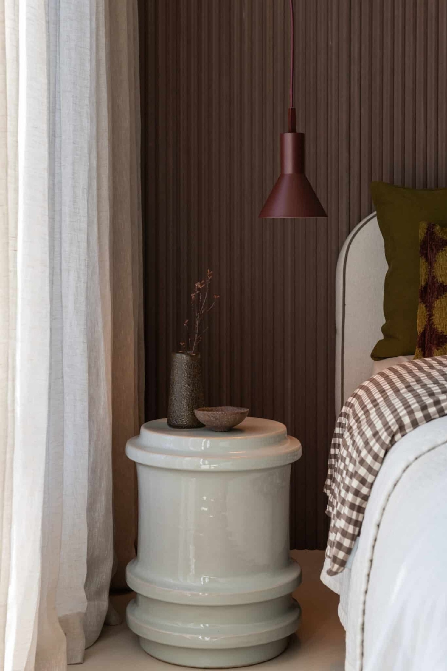 De Stavanger hanglamp in bordeaux hangt verticaal en heeft een cilindrisch bovenste deel met matte afwerking dat overgaat in een uitlopende conische kap. Een bijpassend bordeauxkleurig snoer loopt vanaf de bovenste aansluiting, terwijl de onderste rand een warme, goudkleurige binnenzijde laat zien.