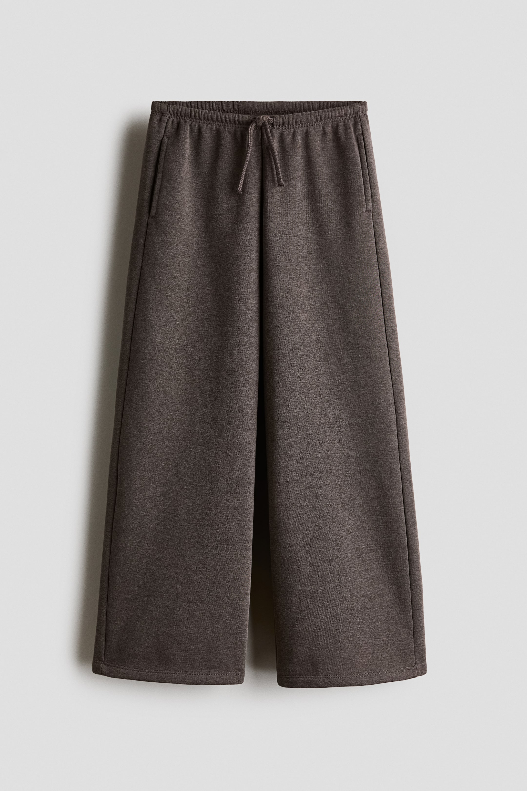 Voir une image plus grande: Un pantalon de jogging en molleton chiné gris foncé est présenté de face. Il est doté d’une taille élastique avec cordon de serrage, de poches latérales discrètes et de jambes droites à coupe large.