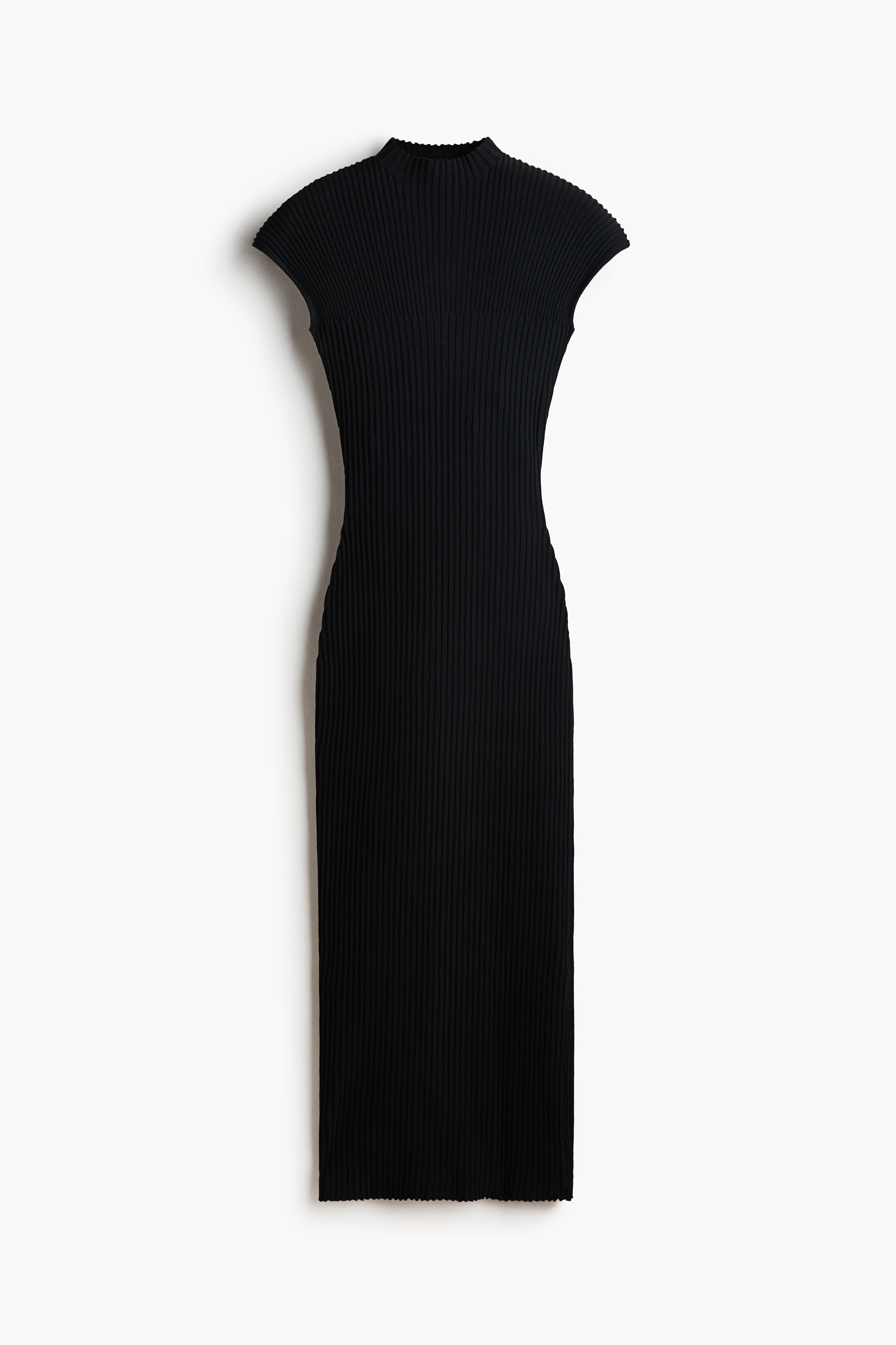 A model is wearing a calf-length, fitted black dress in a high-density rib knit, showcasing its body-hugging silhouette from the front. The dress features a high turtleneck, cap sleeves, and a straight hem.