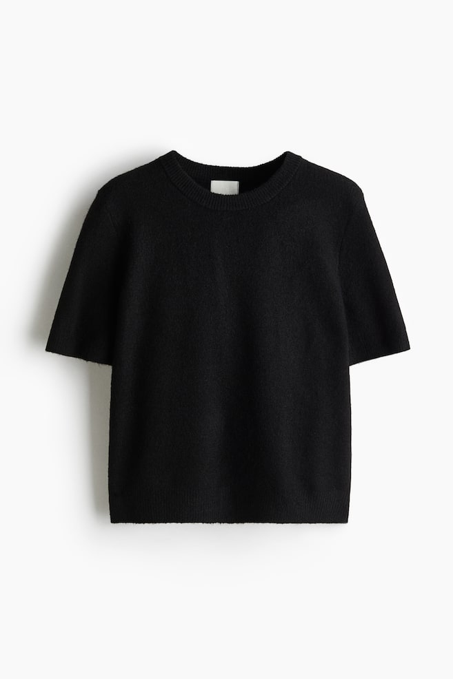 A black, soft, fine-knit jumper is displaying its FRONT, and is featuring a round neckline and short sleeves. Ribbing is detailing the neckline, cuffs, and hem. - 1