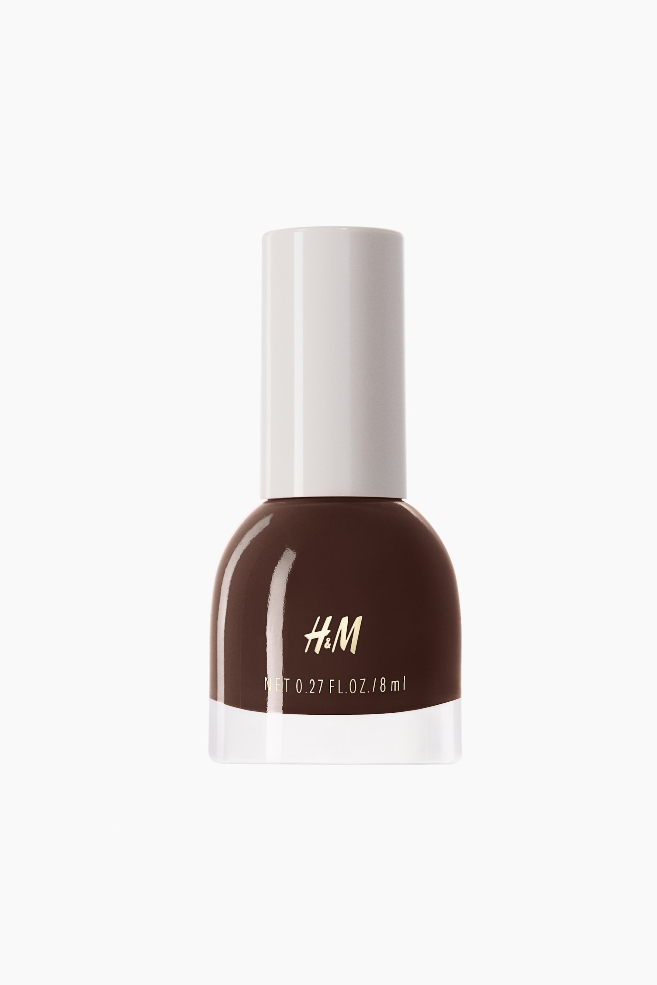 Grotere afbeelding bekijken: Een nagellakflesje staat naar voren gericht, met een afgerond zwart glazen lichaam met een transparante basis, een witte cilindrische dop en gouden 'H&M' branding met 'NET 0.27 FL. OZ. / 8 ml' tekst aan de voorzijde.