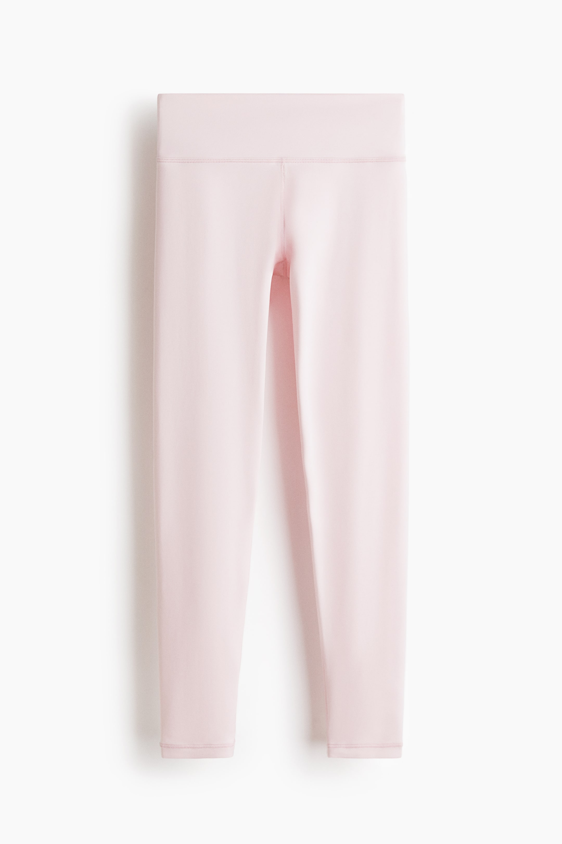 Agrandir l'image: Un legging de sport rose pâle est présenté de face, avec une large ceinture taille haute et des coutures plates courant le long des jambes jusqu'à une longueur raccourcie.