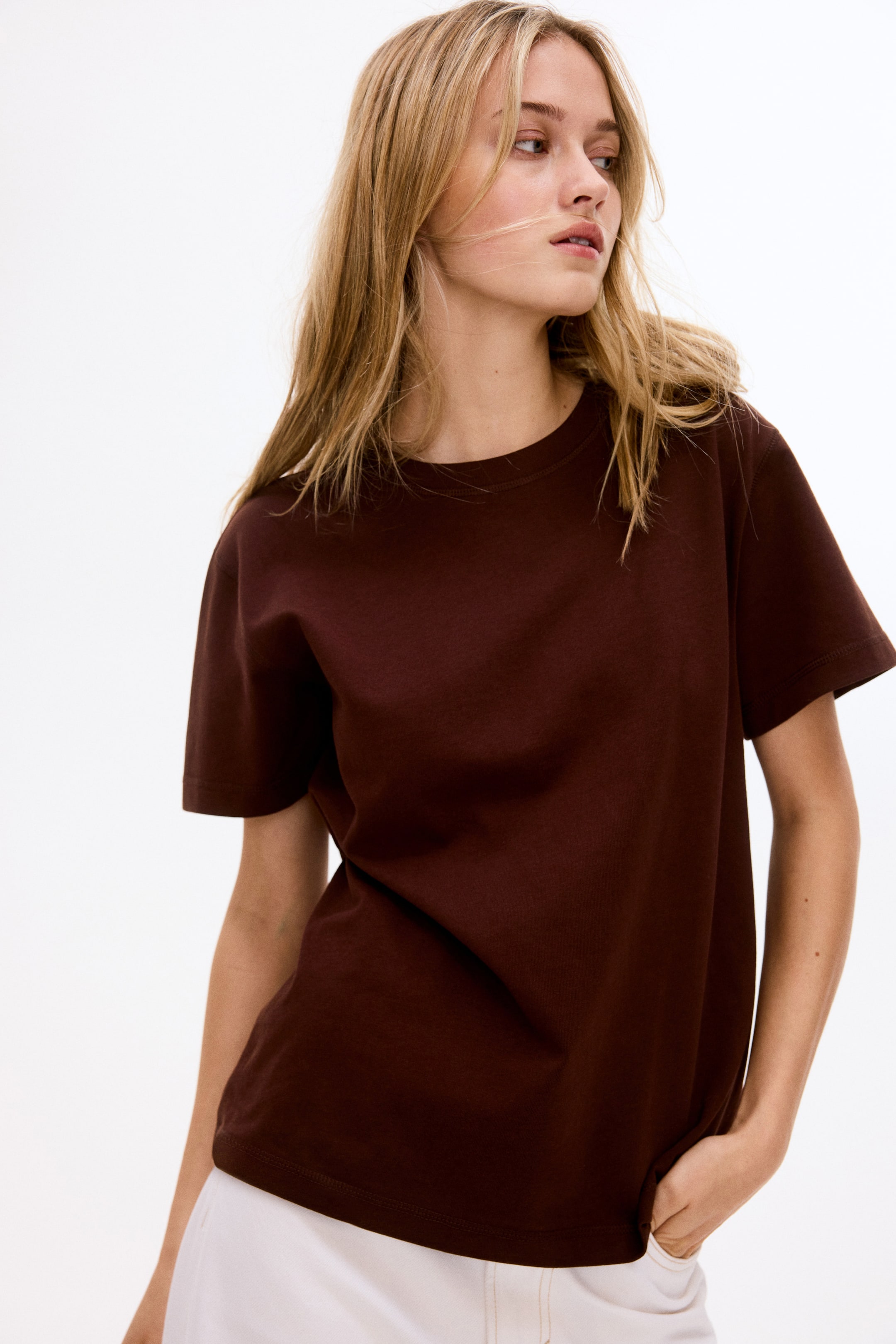Agrandir l'image: Un t-shirt brun foncé avec un col rond et des manches courtes, présentant une coupe décontractée avec un ourlet droit.