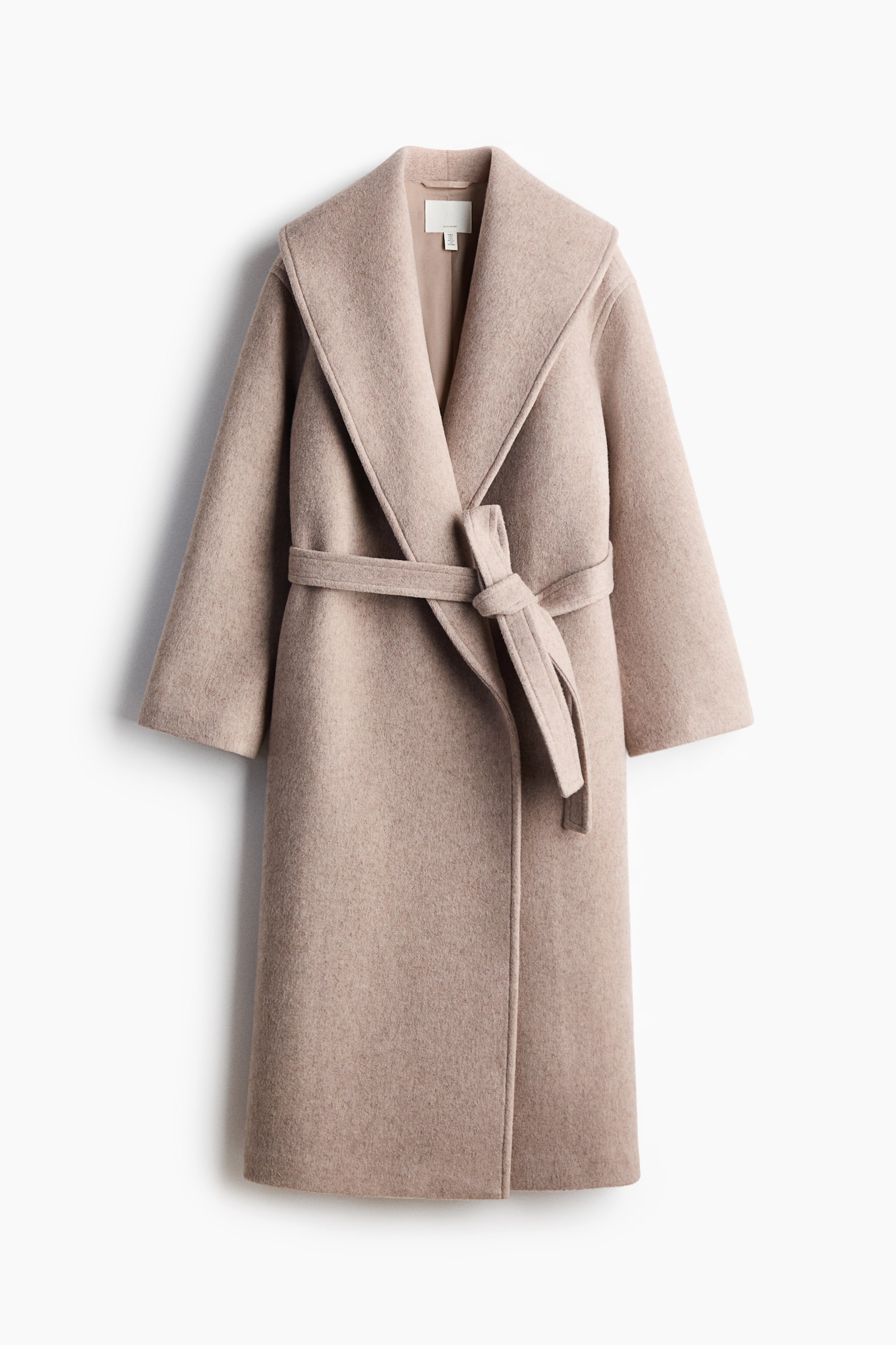Un lungo cappotto in misto lana infeltrita color beige chiaro Ã¨ appeso in una vista frontale, mettendo in risalto un ampio collo a scialle e maniche lunghe morbide. Il cappotto Ã¨ chiuso da una cintura coordinata da annodare in vita, che lascia intravedere una fodera interna liscia tono su tono sullo scollo.