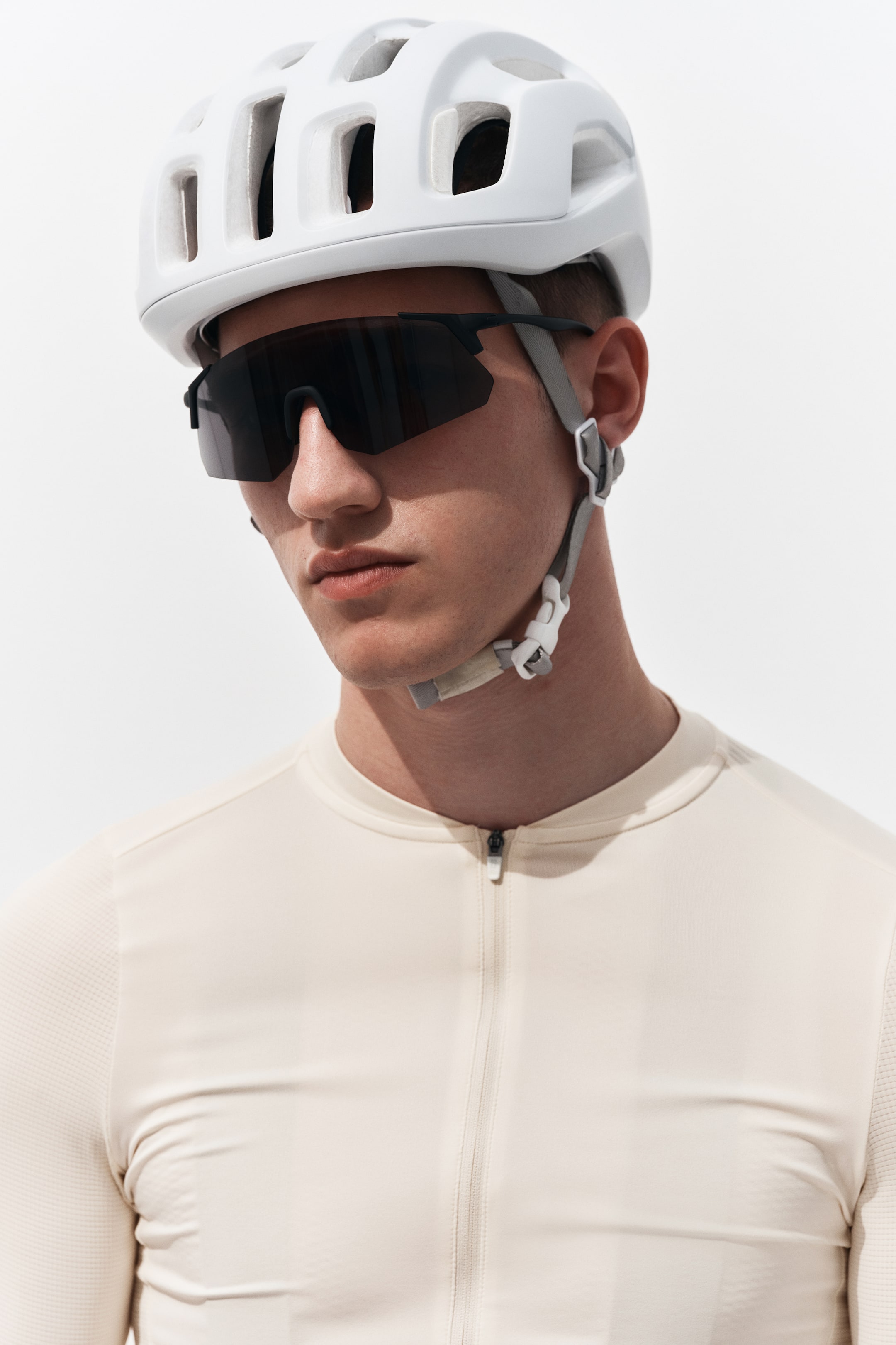 Voir une image plus grande: Un maillot de cyclisme à manches longues de couleur beige clair est doté d'une fermeture éclair frontale pleine longueur et d'un col rond. Il présente un tissu de corps lisse avec un motif texturé subtil sur les manches.
