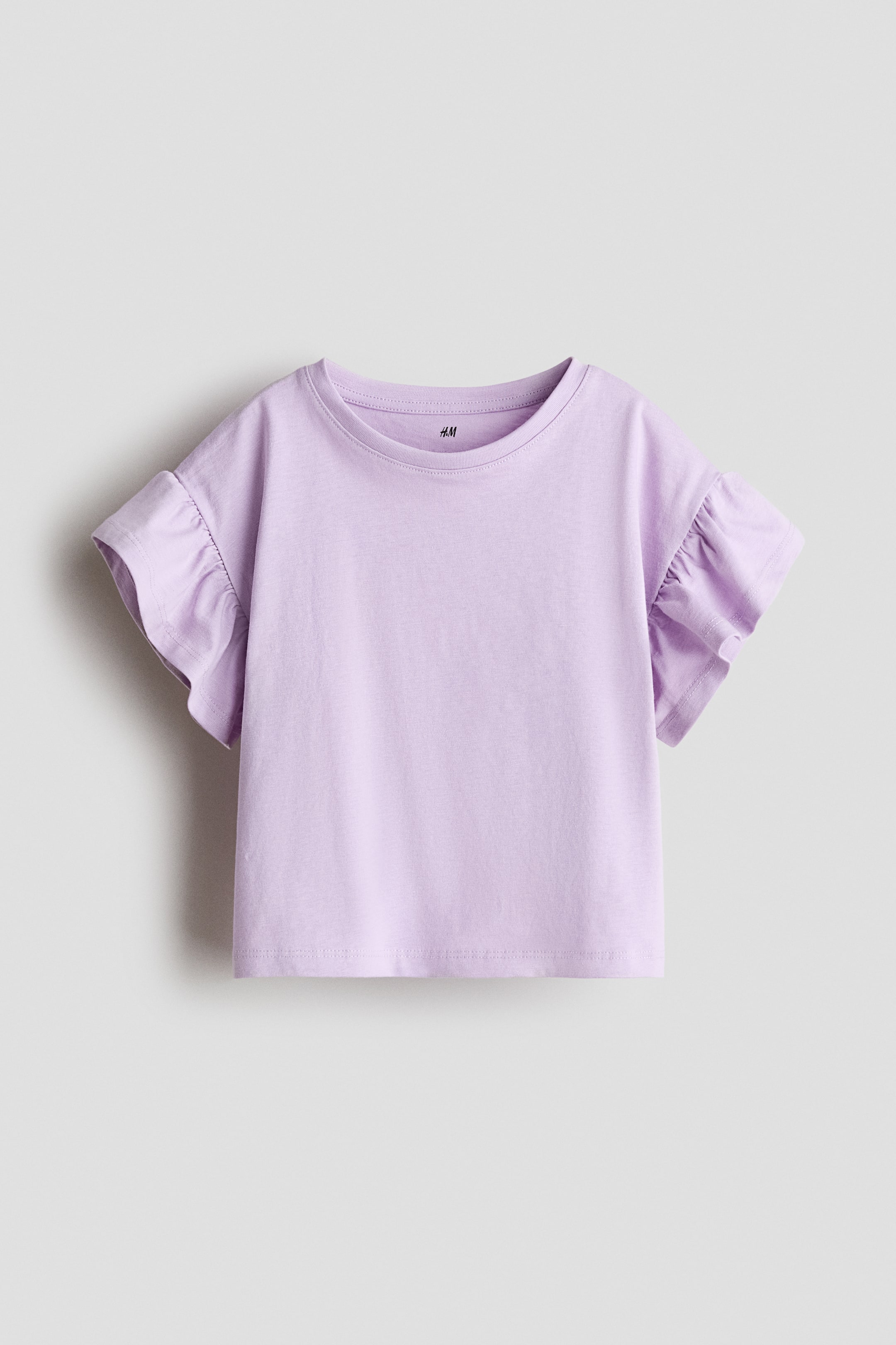 View larger image: A lavender t-shirt features a round neckline, short sleeves with gathered ruffles, and a straight hem.