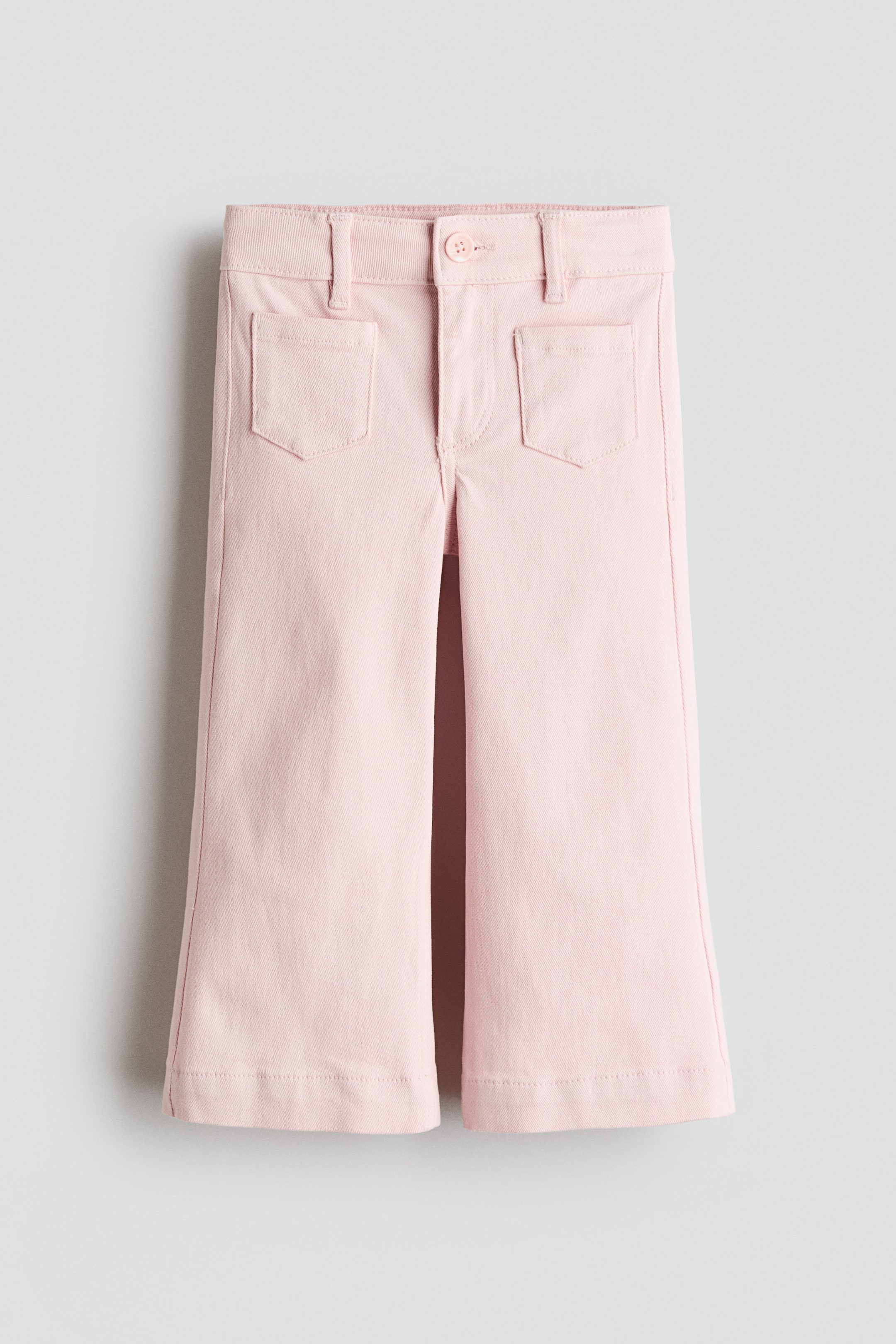 Visualizza immagine più grande: Pantaloni rosa pallido alla caviglia in twill di cotone, con una vestibilità regolare su fianchi e cosce, che si allargano verso il fondo. Presentano una chiusura frontale con bottone e zip e due tasche applicate sul davanti.