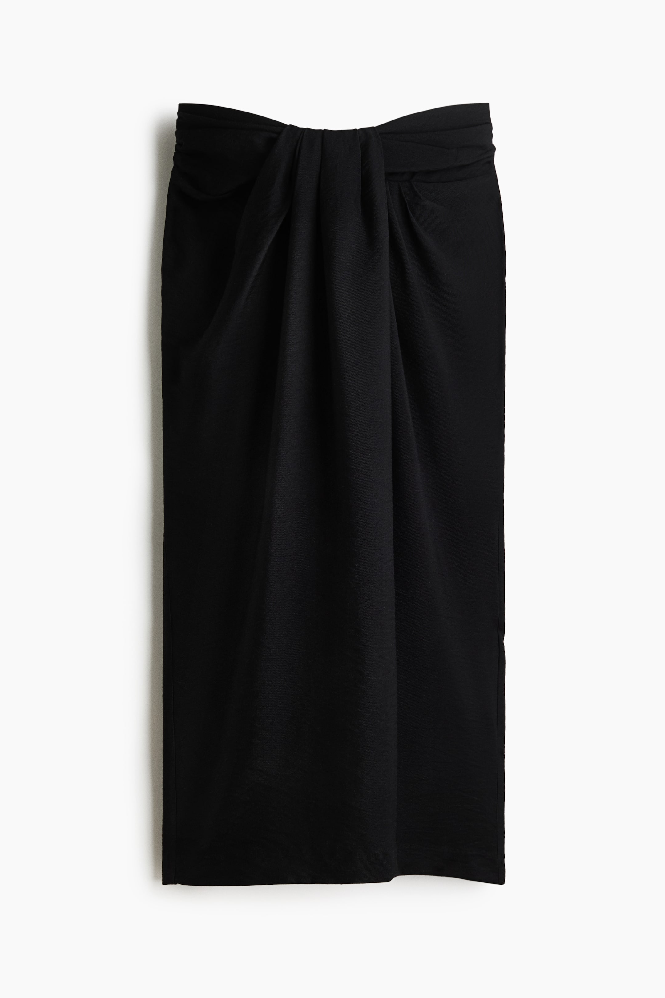 Zobrazit větší obrázek: Černá midi sukně je otočená čelem, s detailem drapérie a uzlu v pase. Sukně má texturovanou látku s jemnými vertikálními záhyby.